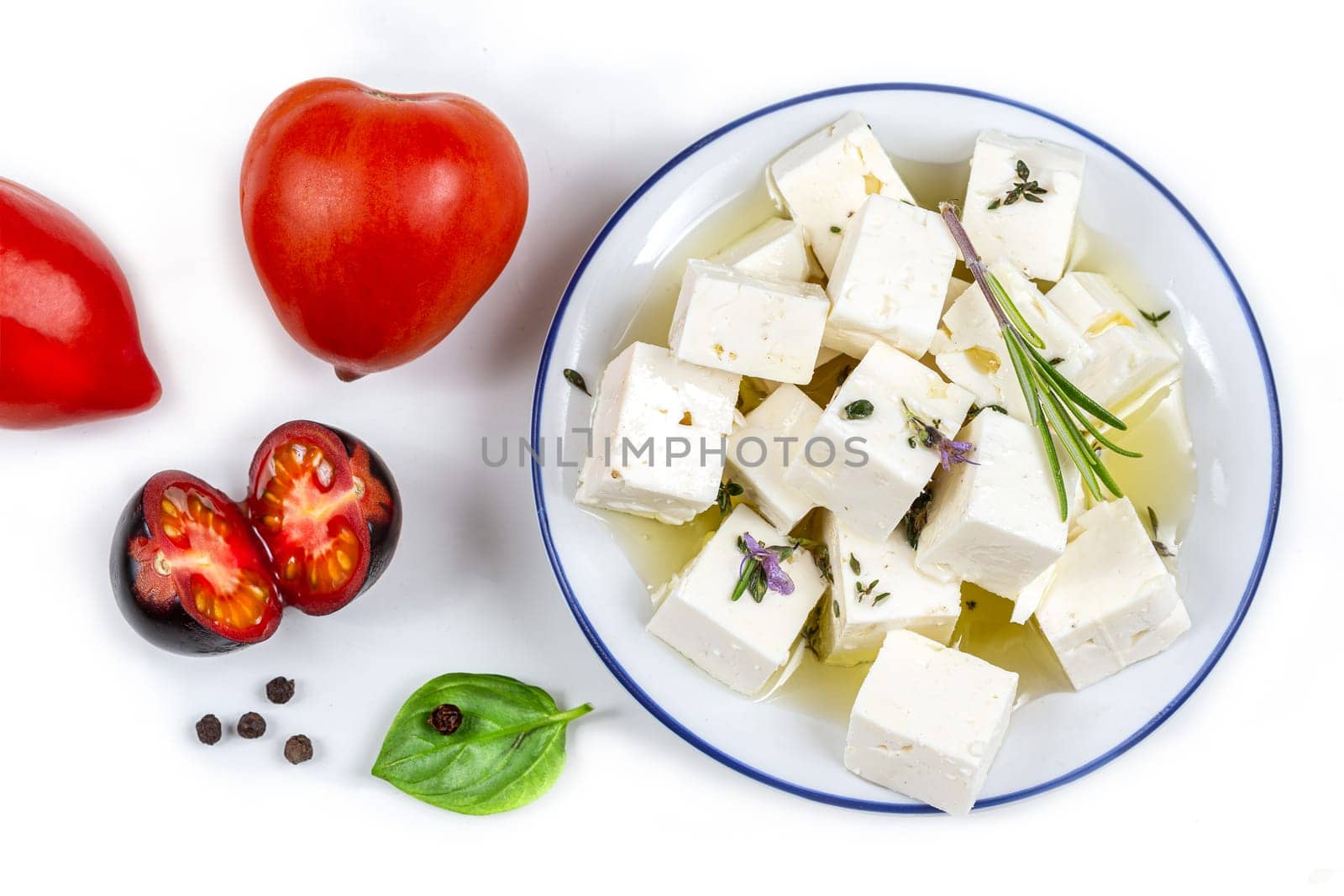 tomatoes with leaves feta cheese and basil isolated on a brown background by JPC-PROD