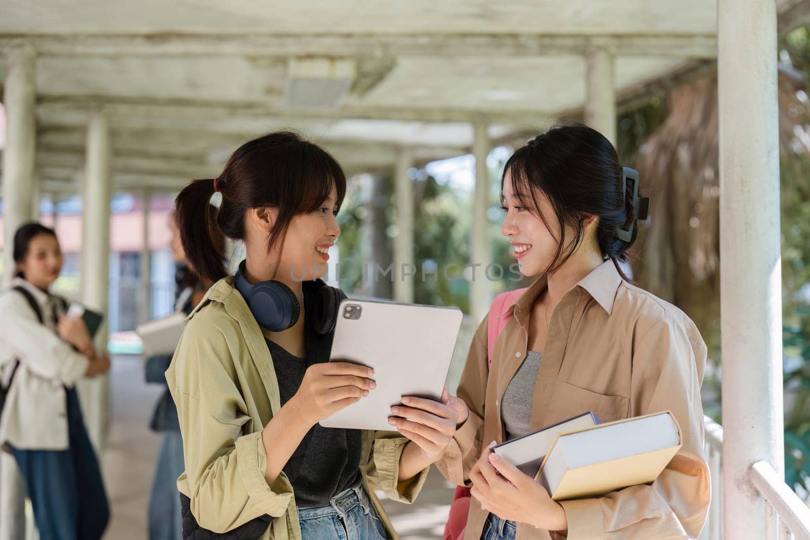 university students using a digital tablet while walking to next class.