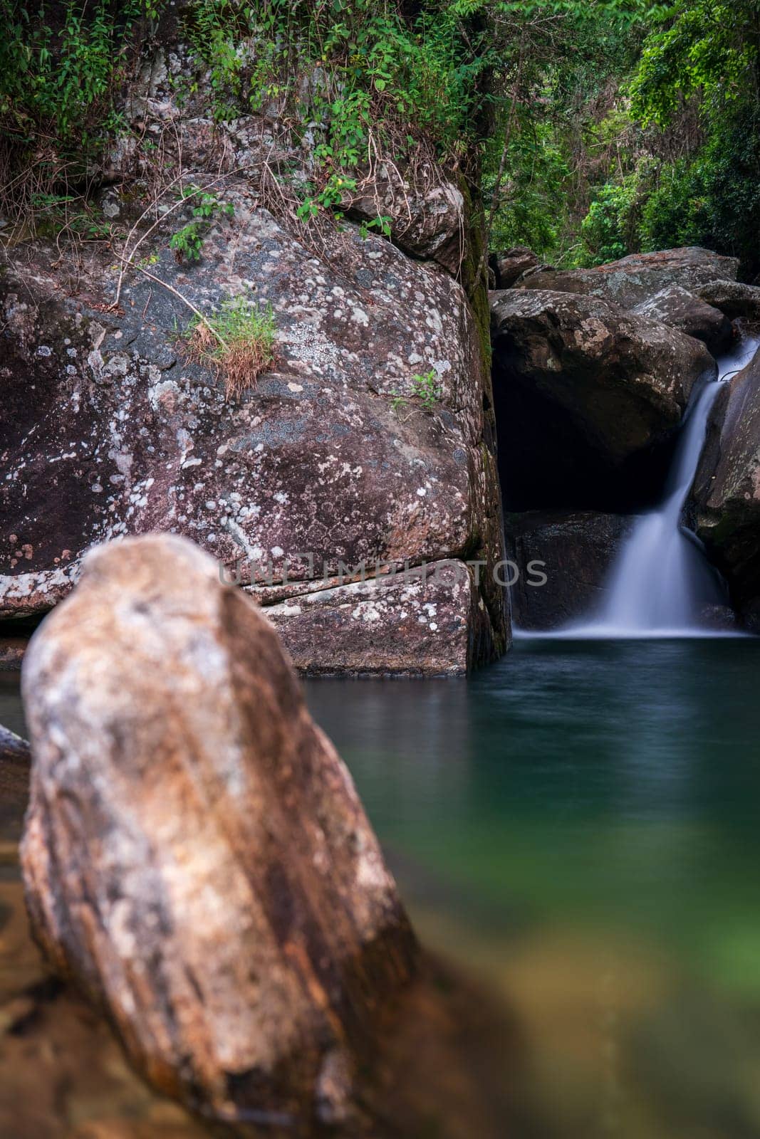 Hidden Waterfall in Tropical Rainforest with Rocky Riverbed by FerradalFCG