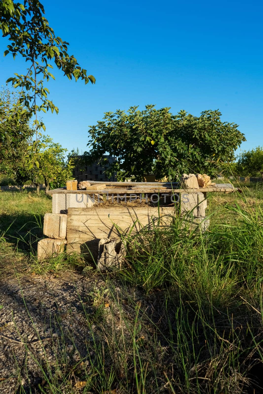 Artisanal composter built rustically, is full of branches and biological remains in rot