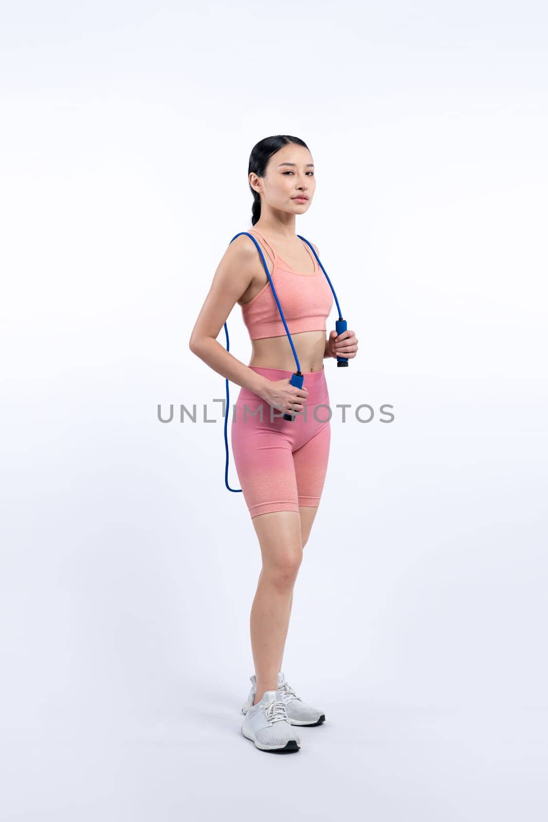 Young energetic asian woman in sportswear with jumping rope. Vigorous by biancoblue