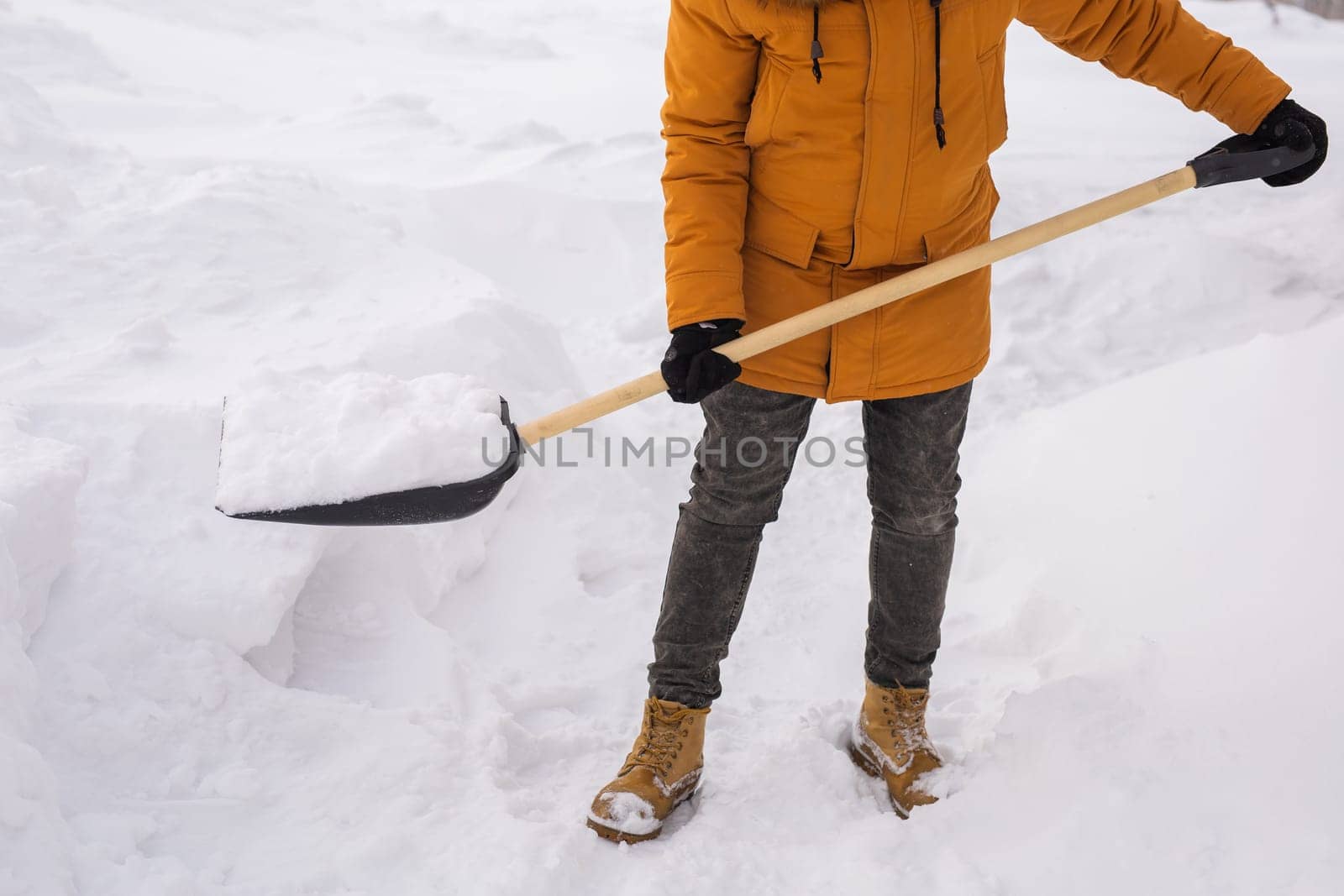 Man is clearing the snow near house and on staircases hovelling at the winter season. Winter storm and season specific.