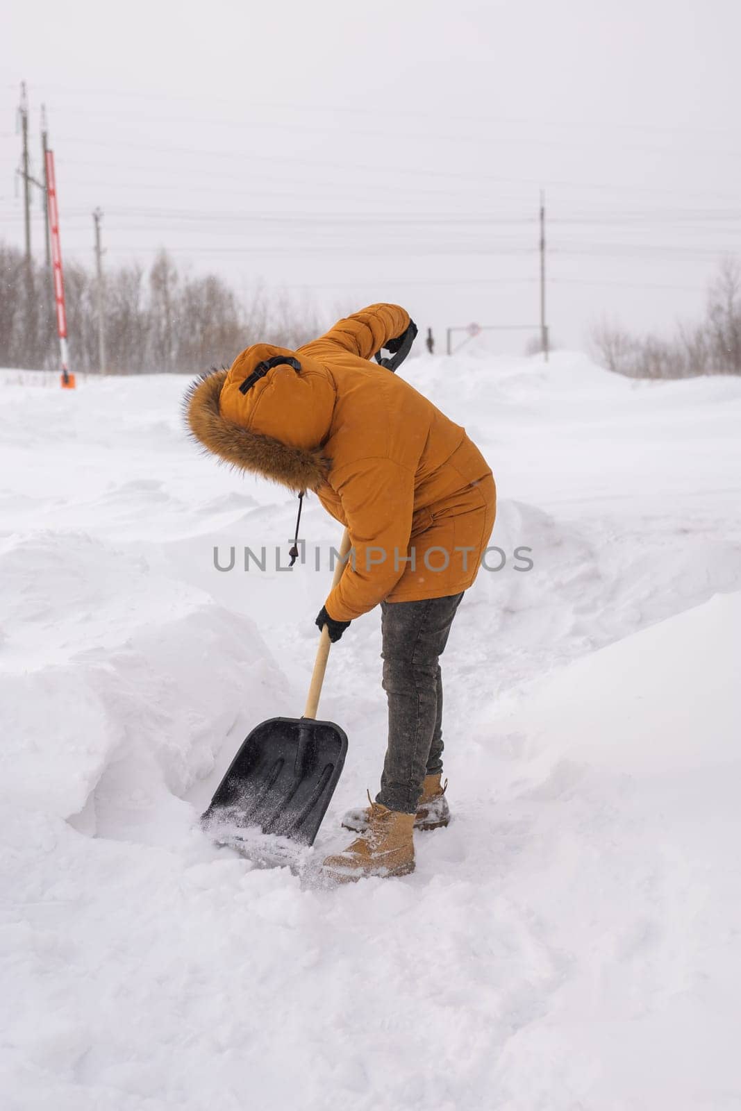 Man is clearing the snow near house and on staircases hovelling at the winter season. Winter storm and season specific by Satura86
