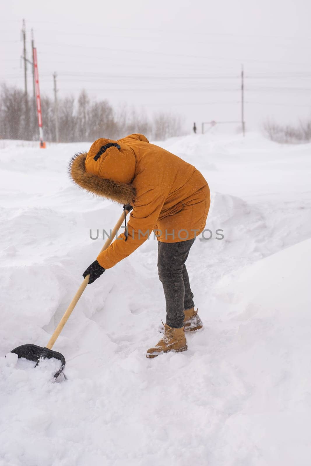 Man cleaning snow from sidewalk and using snow shovel. Winter season.