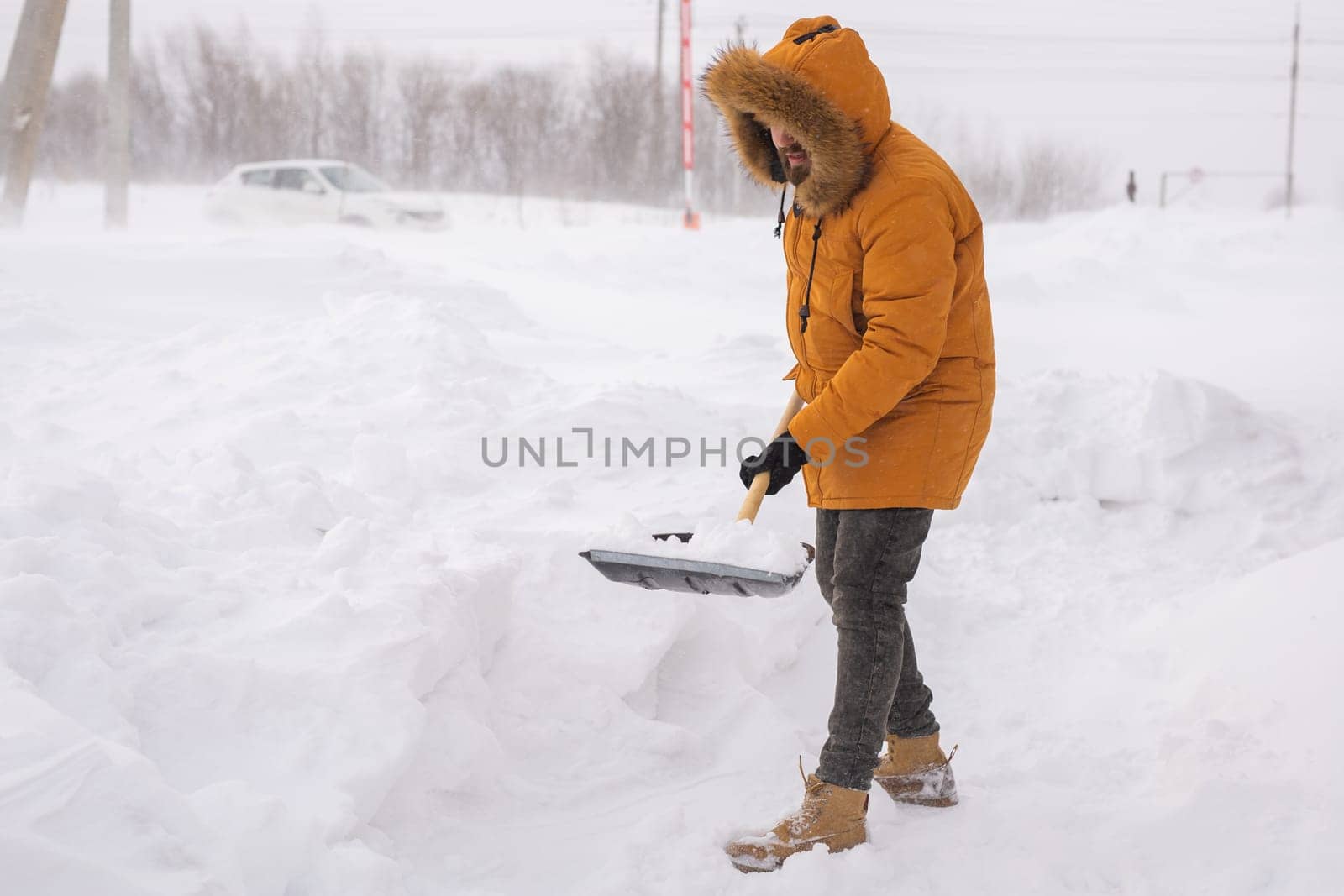 Man removing snow and ice from the sidewalk in front of house. Winter season by Satura86