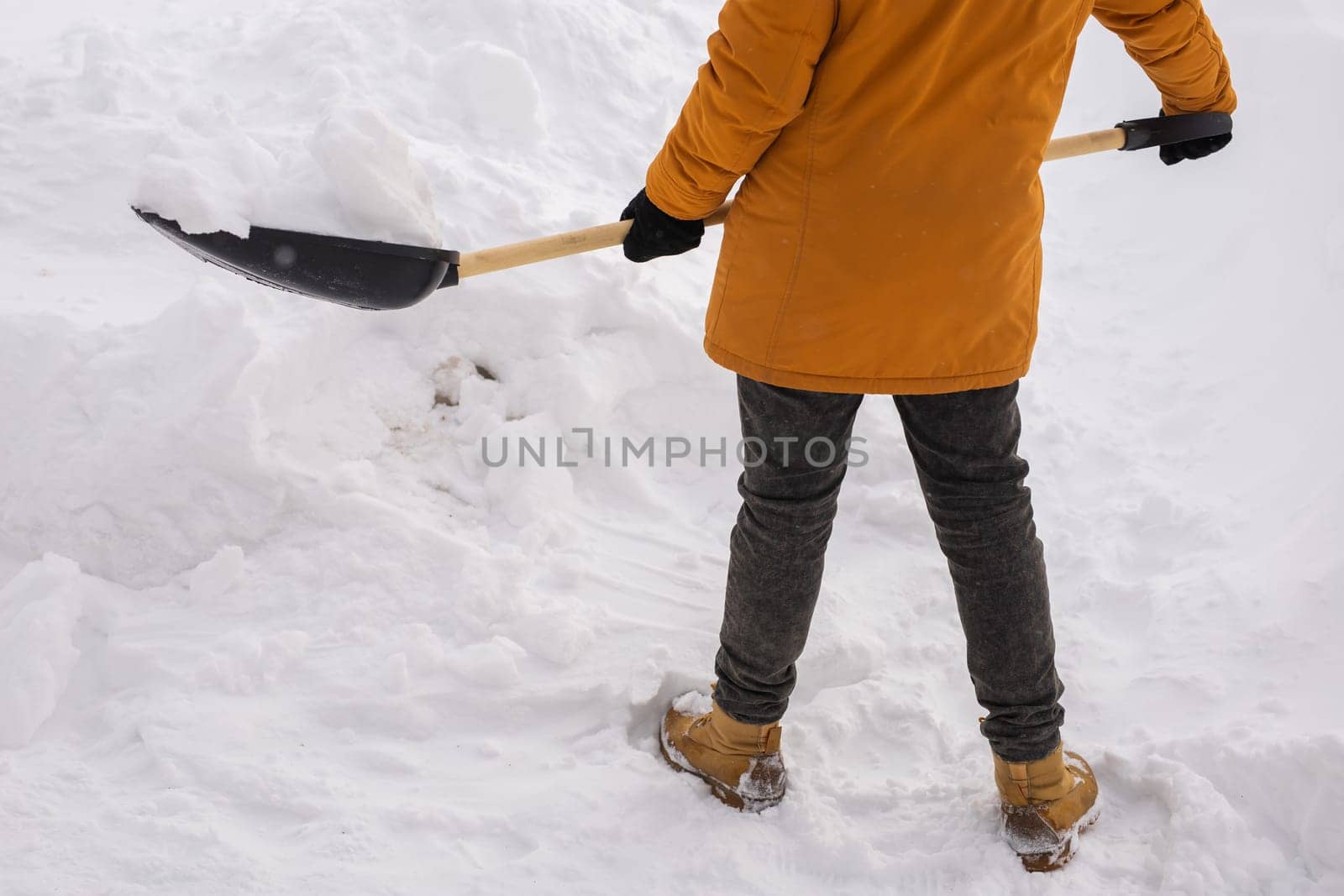 Close-up man is clearing the snow near house and on staircases hovelling at the winter season. Winter storm and season specific by Satura86