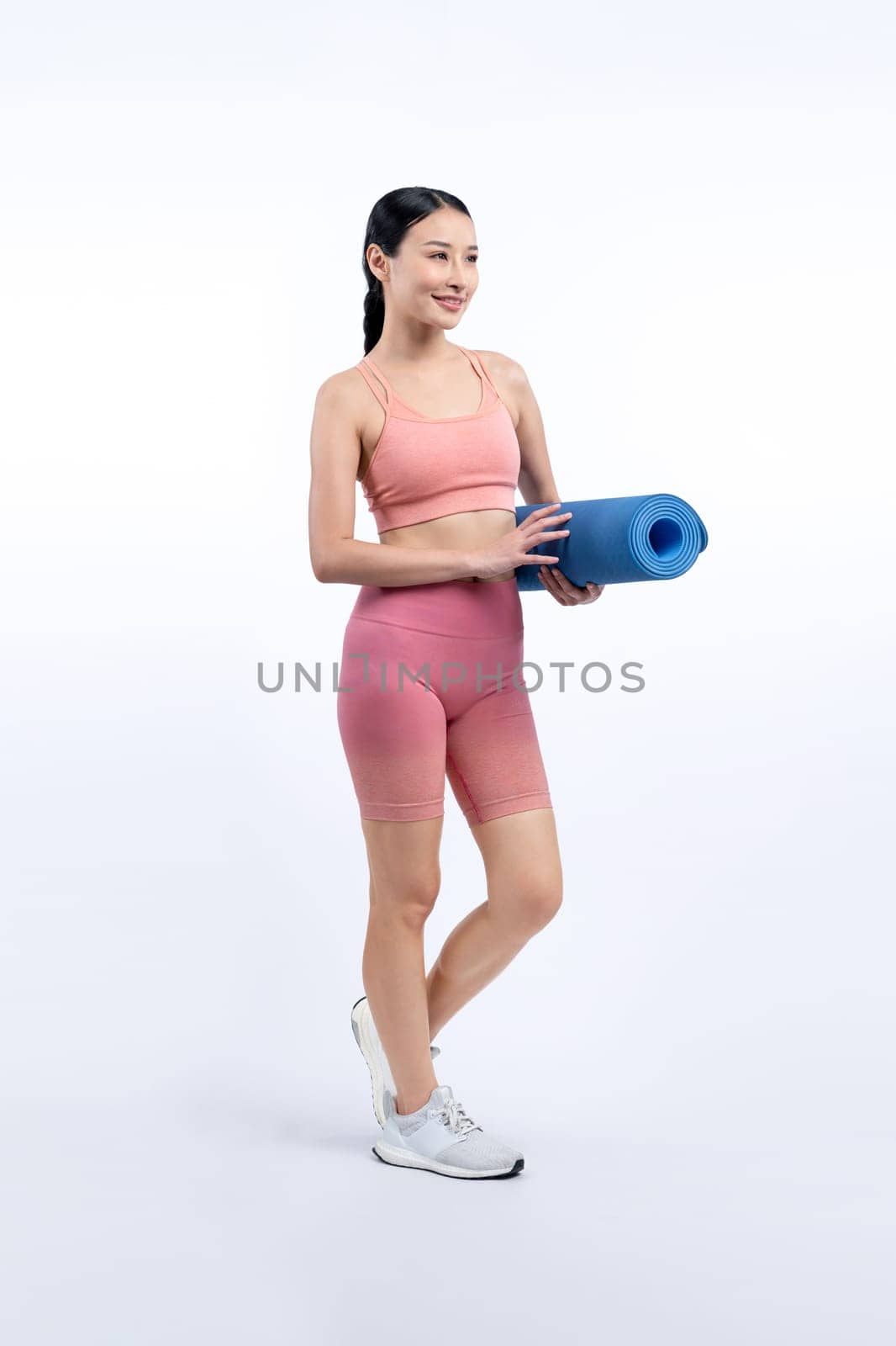 Young attractive asian woman portrait in sportswear with exercising mat. Healthy exercise and workout routine lifestyle concept. Studio shot isolated background. Vigorous