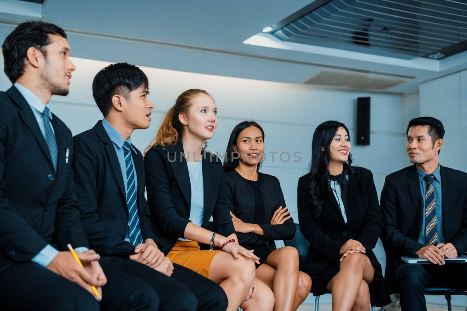 Young Asian and Caucasian audience sitting and listen to speaker in group meeting presentation at office. Businessmen and businesswomen in training workshop. International multicultural business. uds