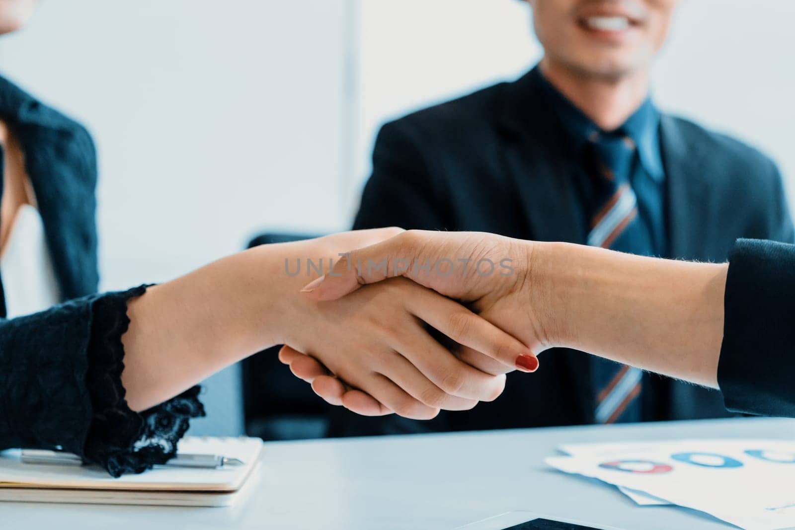 Business people agreement concept. Businessman and Asian businesswoman do handshake in the office. uds