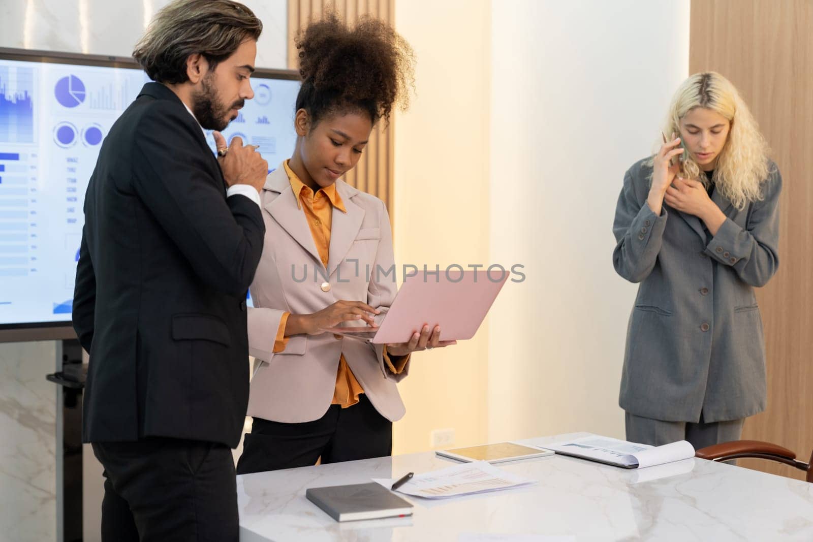 Smart diverse businesspeople working together at business meeting. Executive manager team analysis marketing data by using laptop while businesswoman phone calling to investor. Conference. Ornamented.