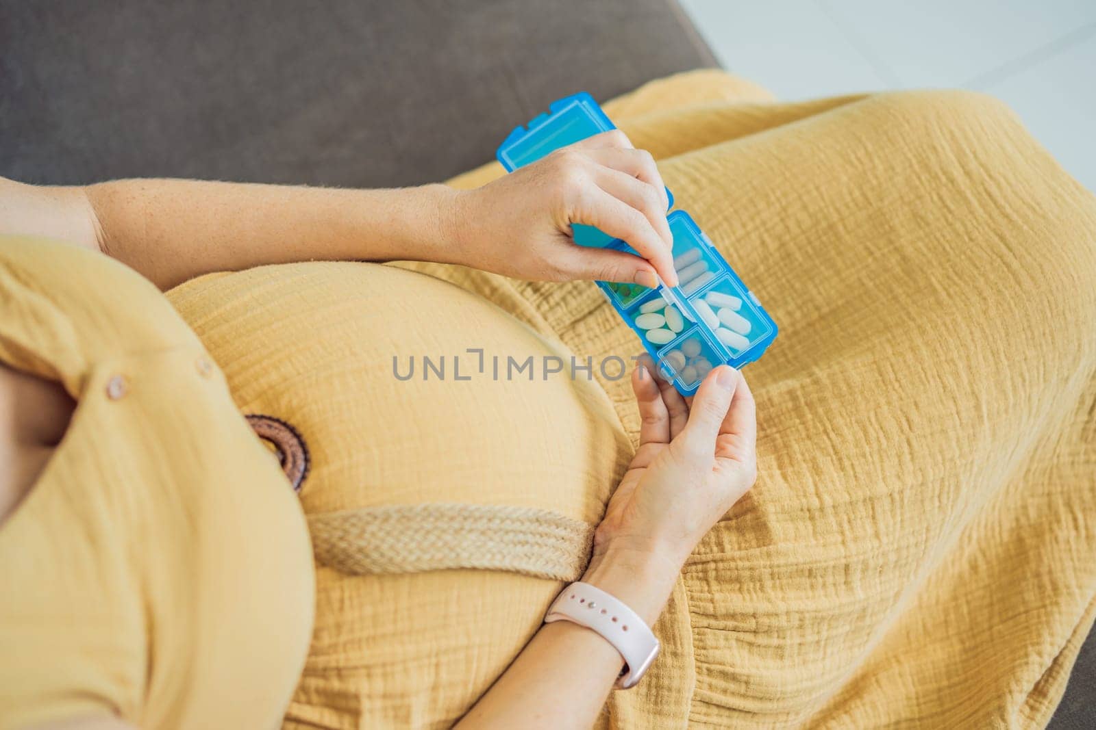 Prenatal Vitamins. Portrait Of Beautiful Smiling Pregnant Woman Holding Pill Box, Taking Supplements For Healthy Pregnancy While Sitting On Couch At Home, Free Space.
