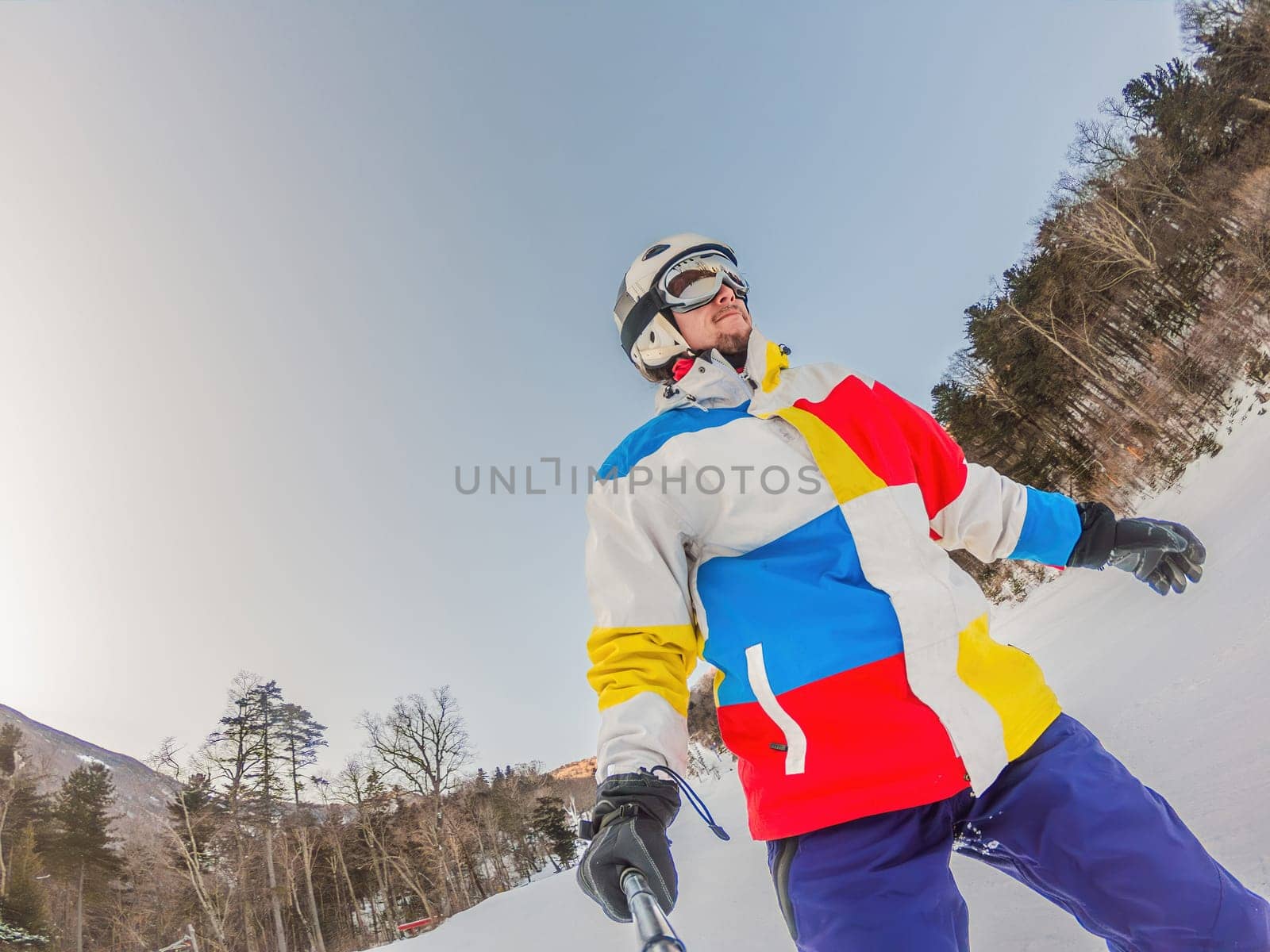 A daring man conquers snowy slopes with style, showcasing skill and thrill as he maneuvers on a snowboard, capturing the essence of winter adventure by galitskaya