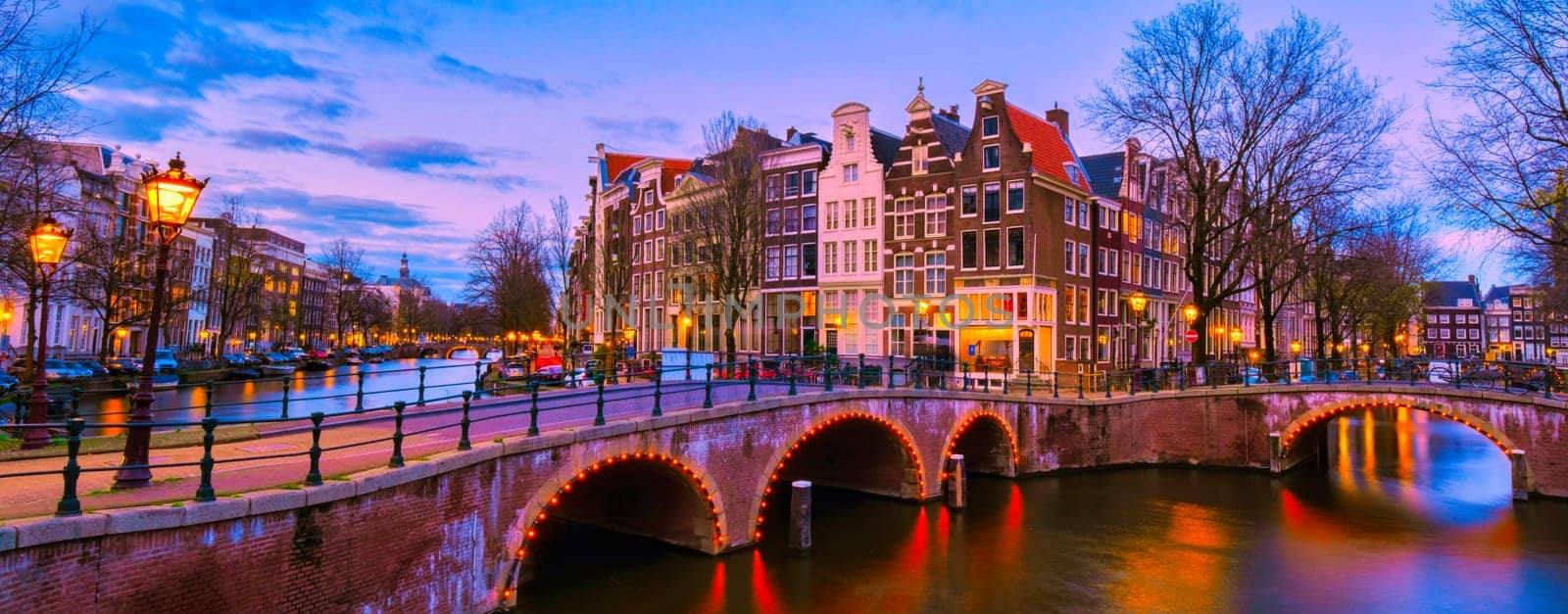 Amsterdam Canal in the evening during sunset, Amsterdam Canal bridge with old historical houses at night in the Netherlands