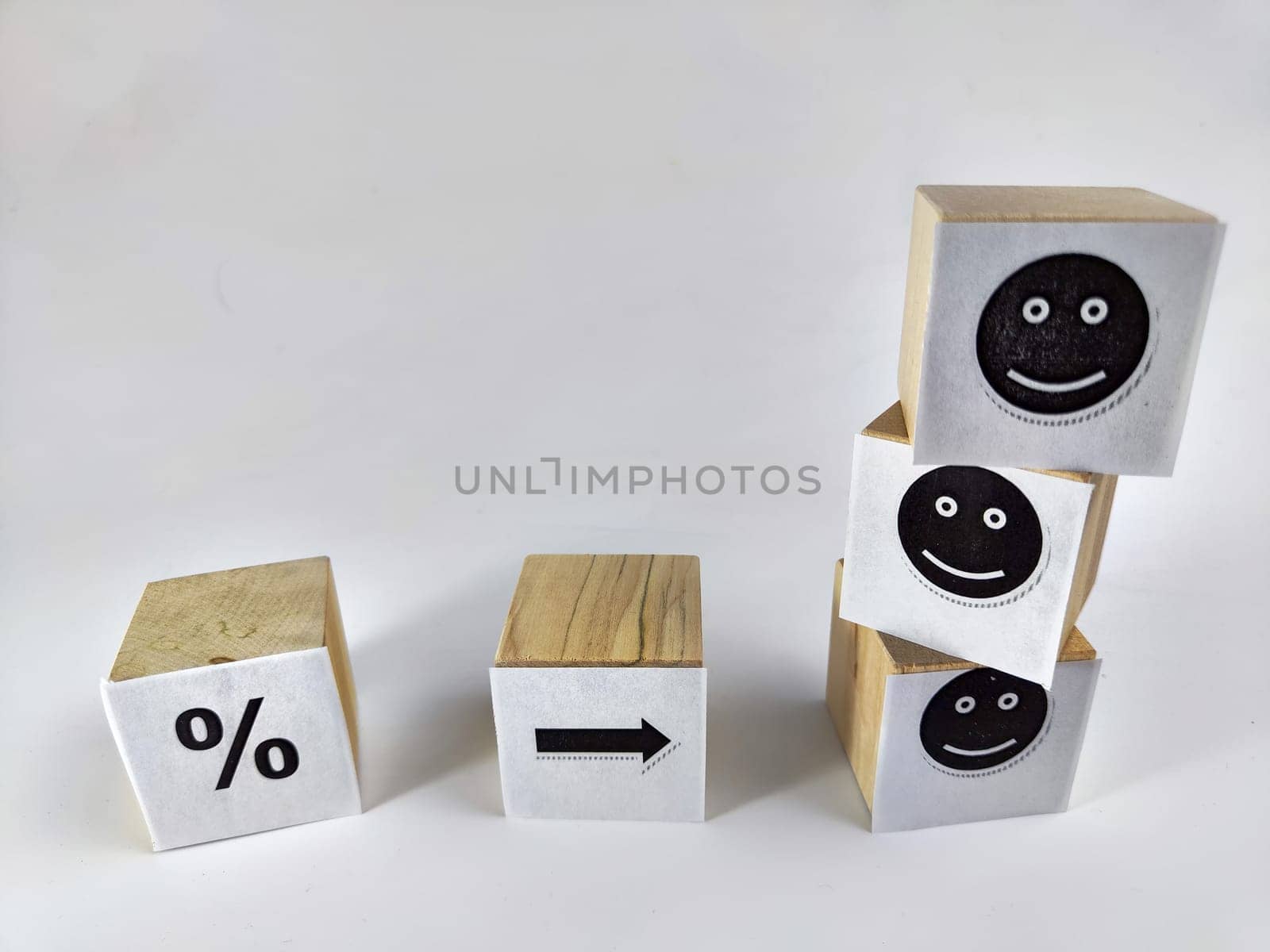 Wooden cubes in a column and a row with white signs with a smiley sign, a percentage. The concept of positivism. Efforts and achievements lead to pleasure, joy, positivism and positive thinking by keleny