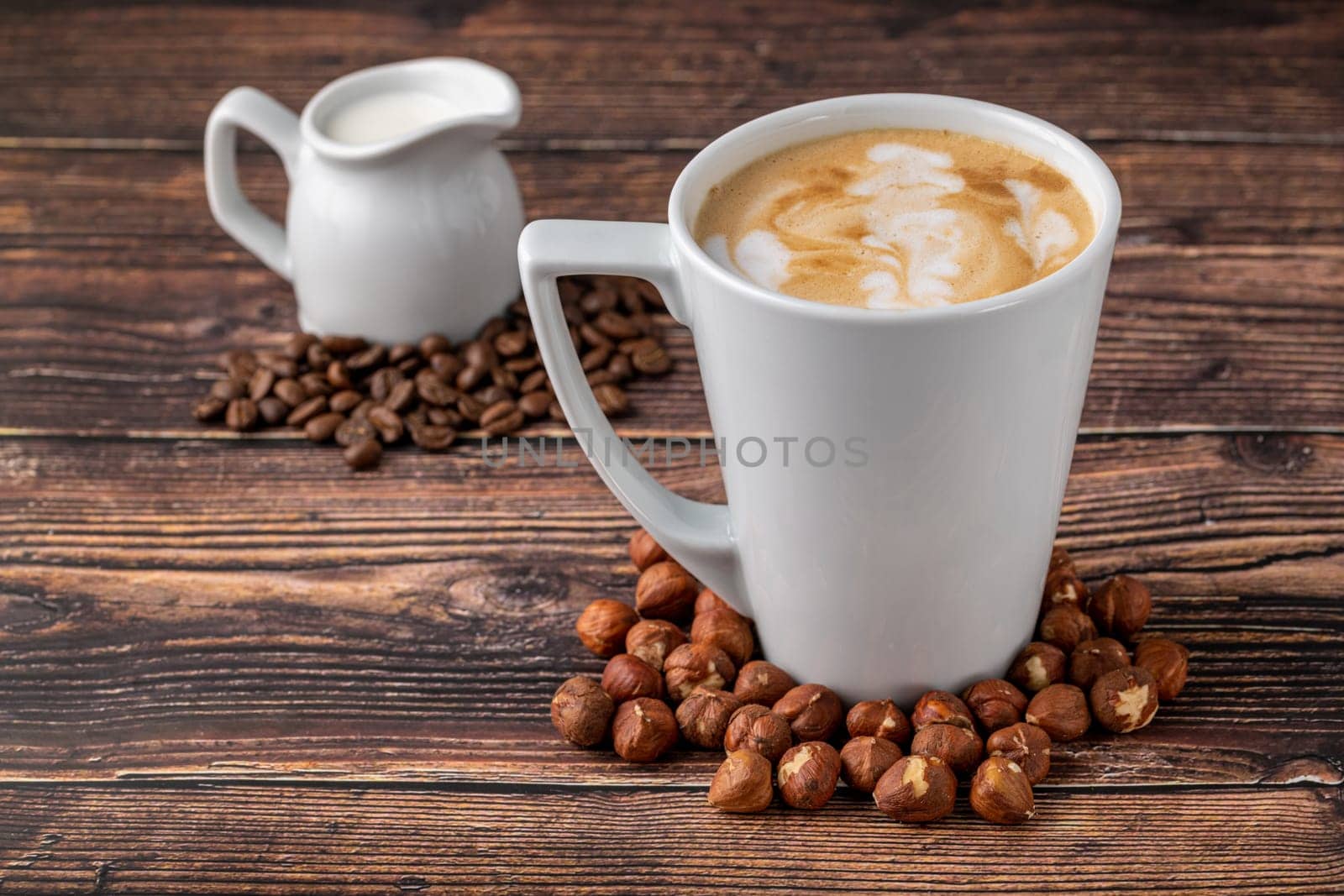 Hazelnut latte in white glass on wooden table