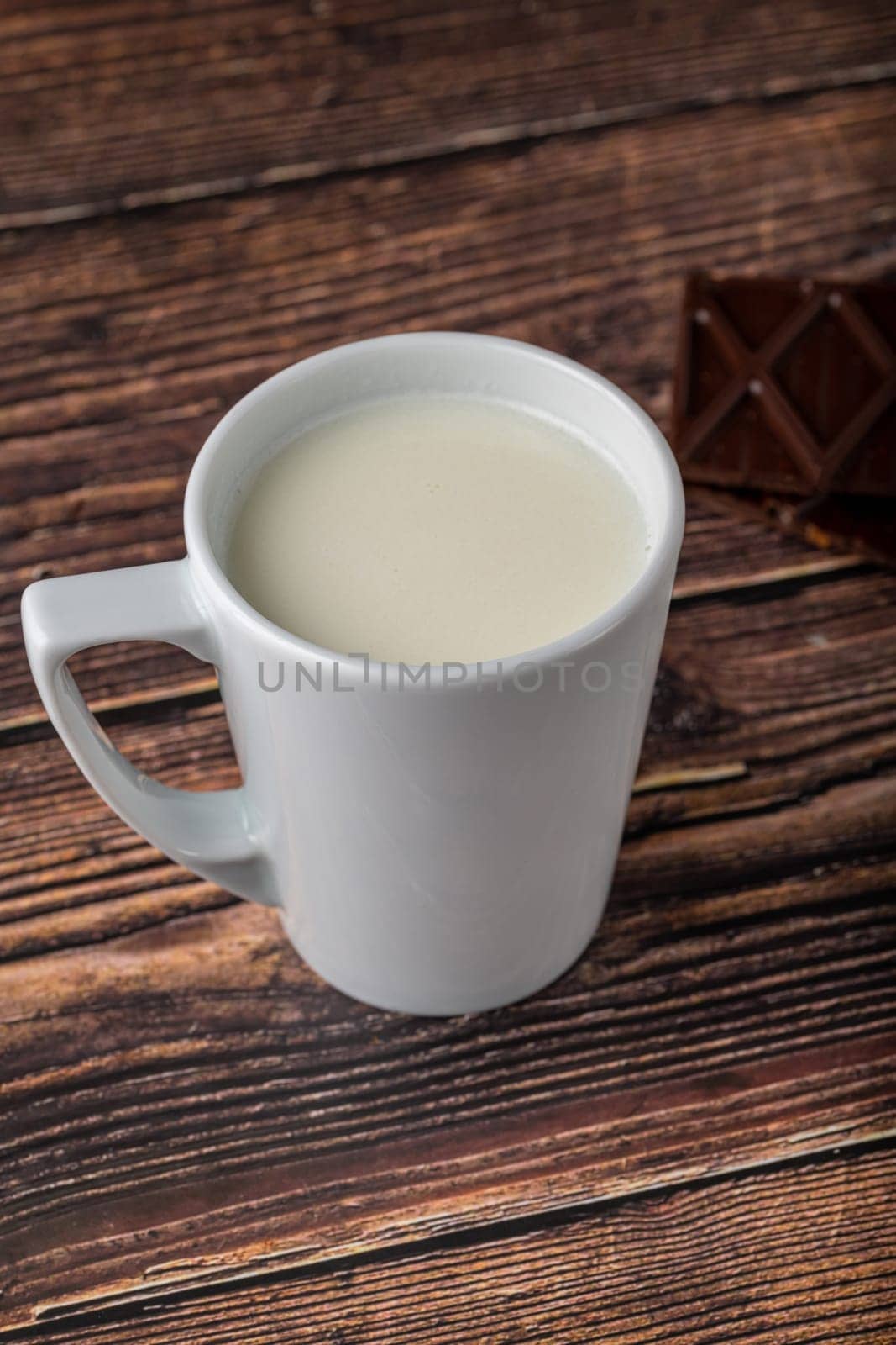 Milk with chocolate in black cup on wooden table