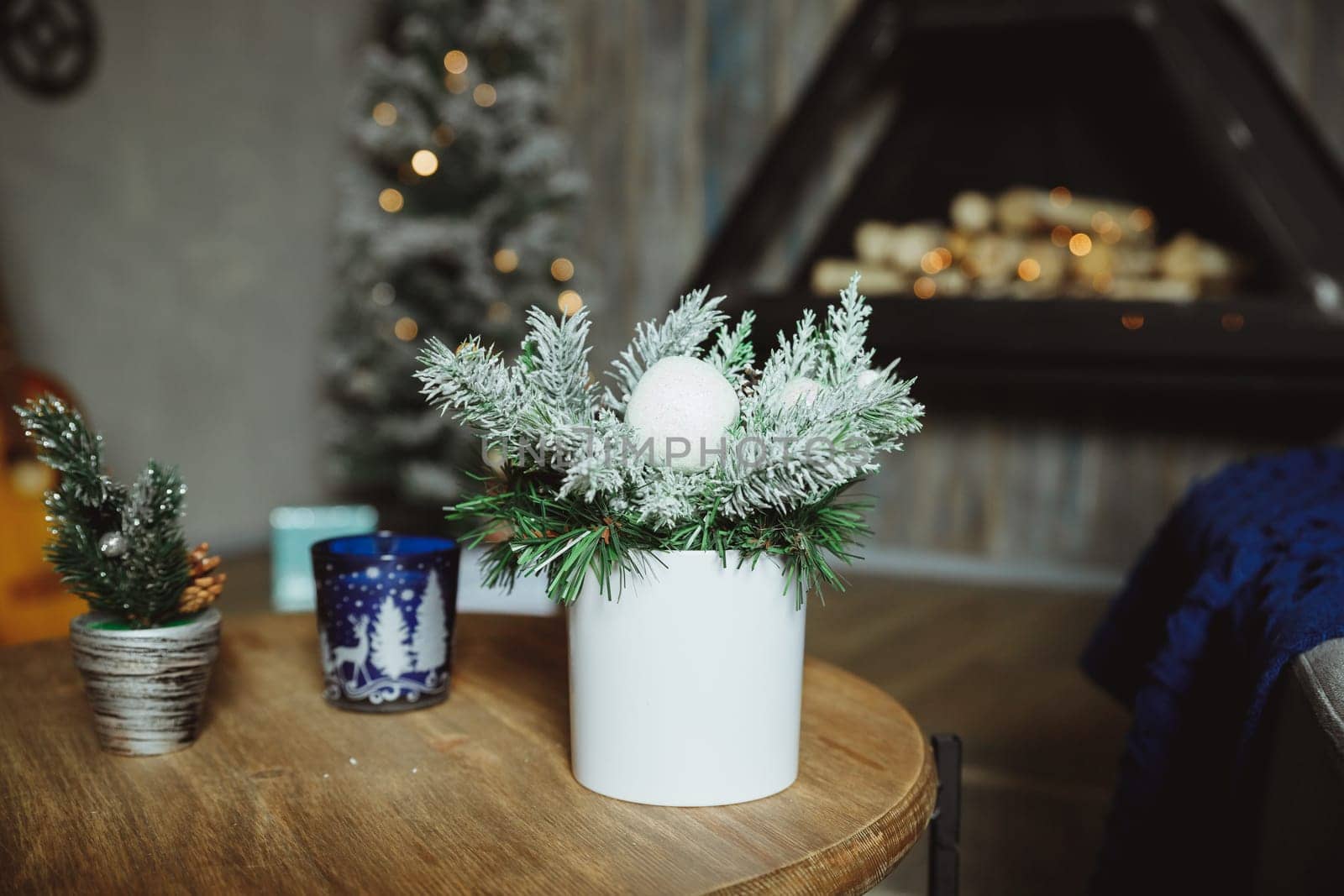 Christmas arrangement with candles. Hands close-up. decorative ornaments. Christmas decor with own hands. The new year celebration.spruce branches on a wooden table. by YuliaYaspe1979