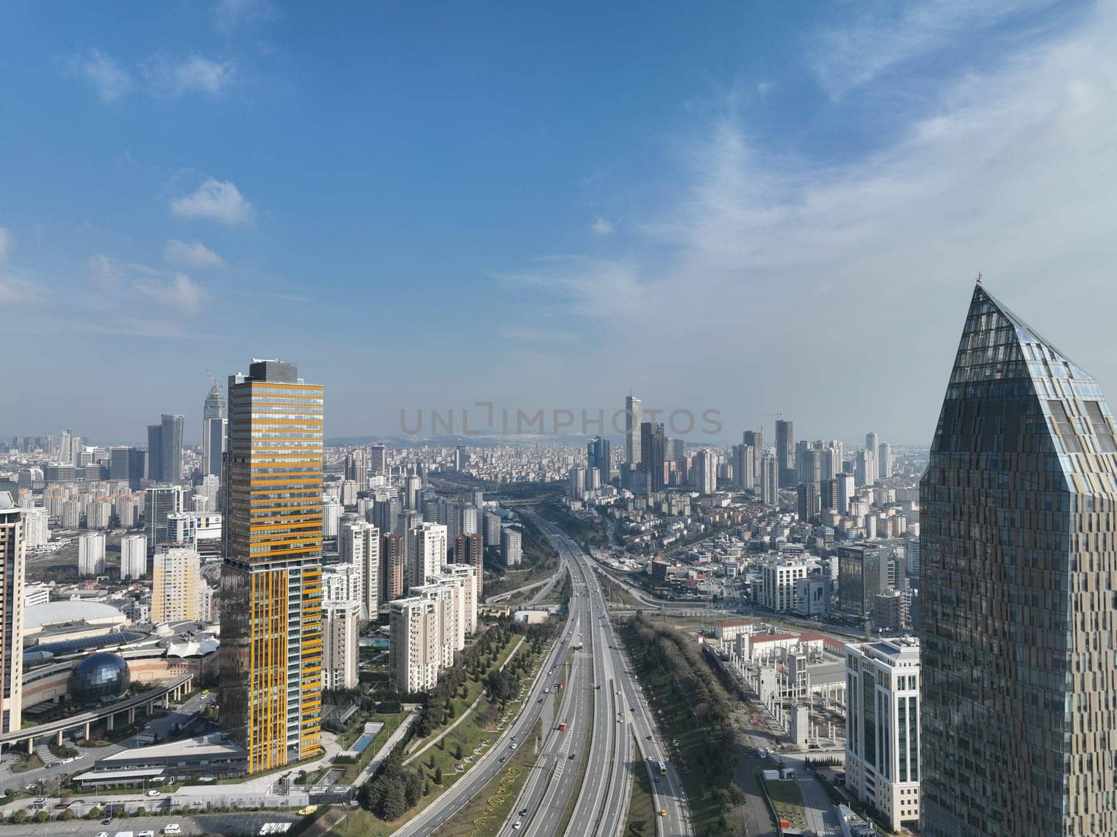 Cinematic aerial view of city skyline, modern business financial skyscrapers building and shopping mall of Istanbul, Turkey at sunny winter day with blue sky drone establishment shot