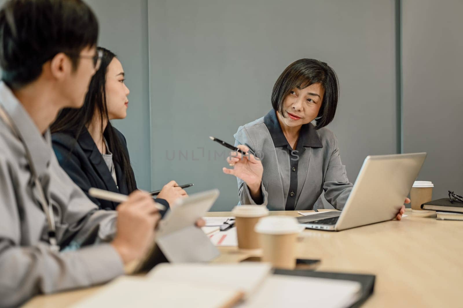 Shot of professional executive businesspeople discussing project planning at meeting table.