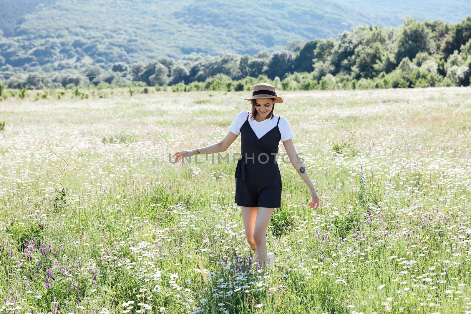 woman in field in flowers in nature walk chamomile journey