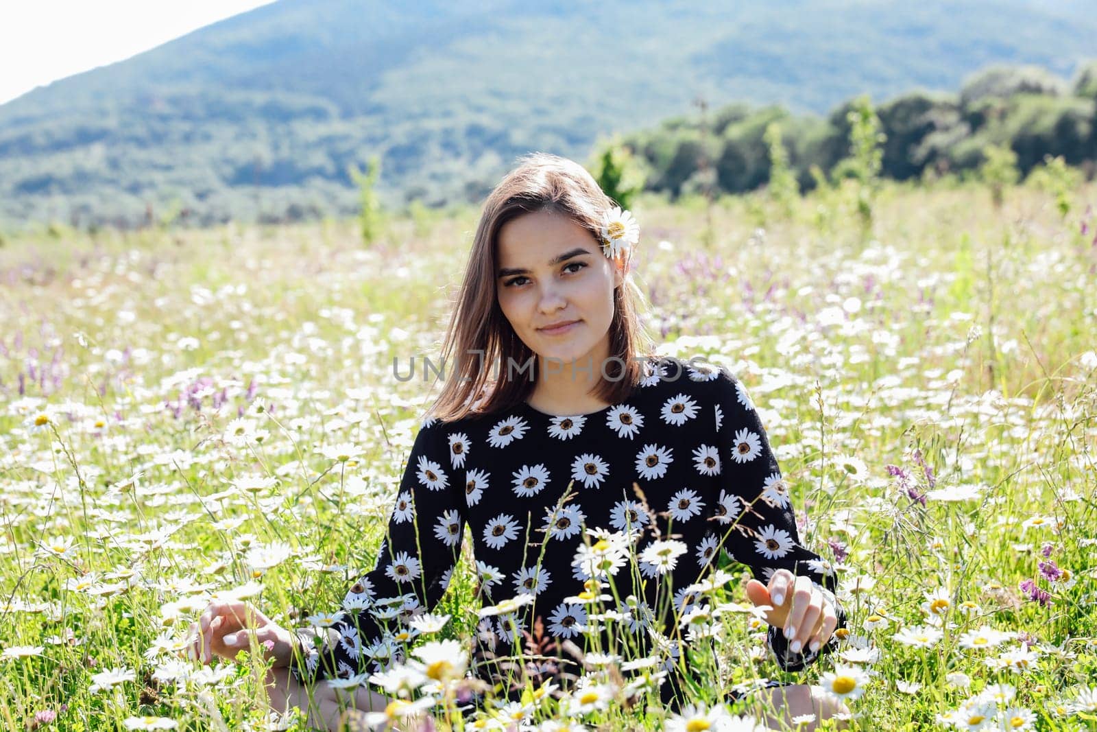 Beautiful woman in field in flowers in nature walk chamomile journey