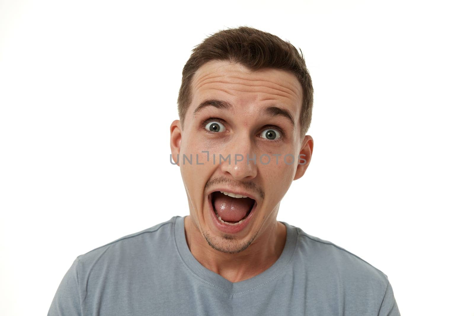 surprised guy looking at camera on white studio background
