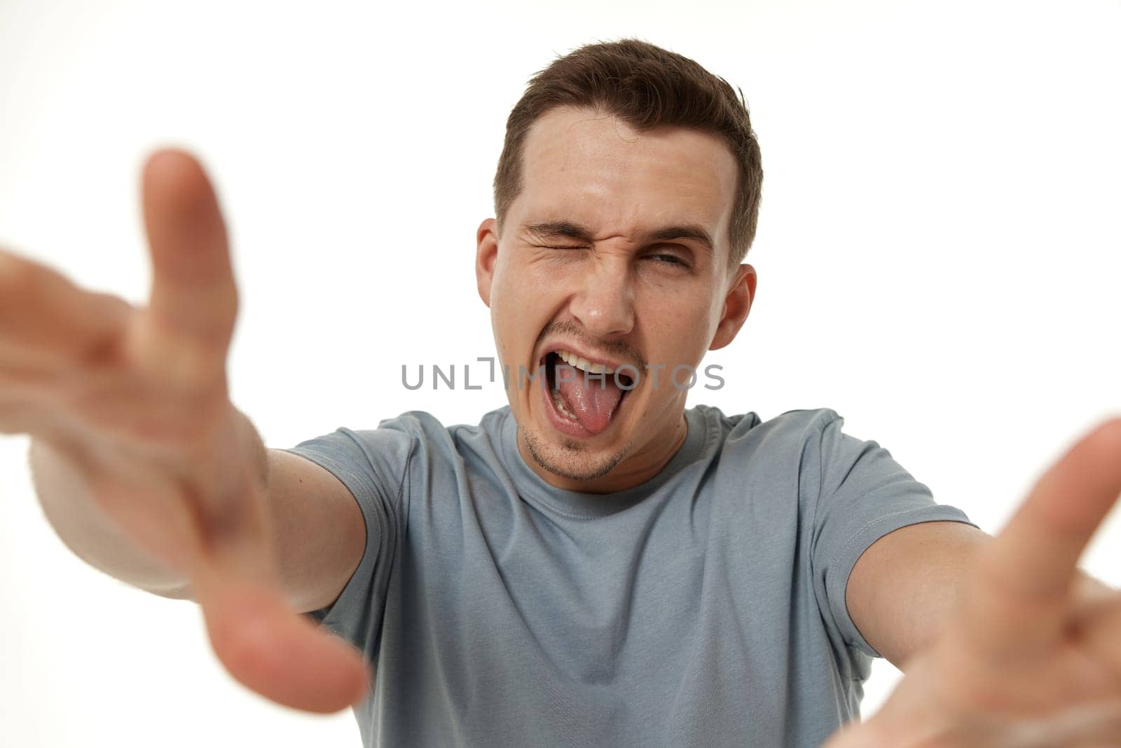 portrait of young happy man winking looking at the camera on white background