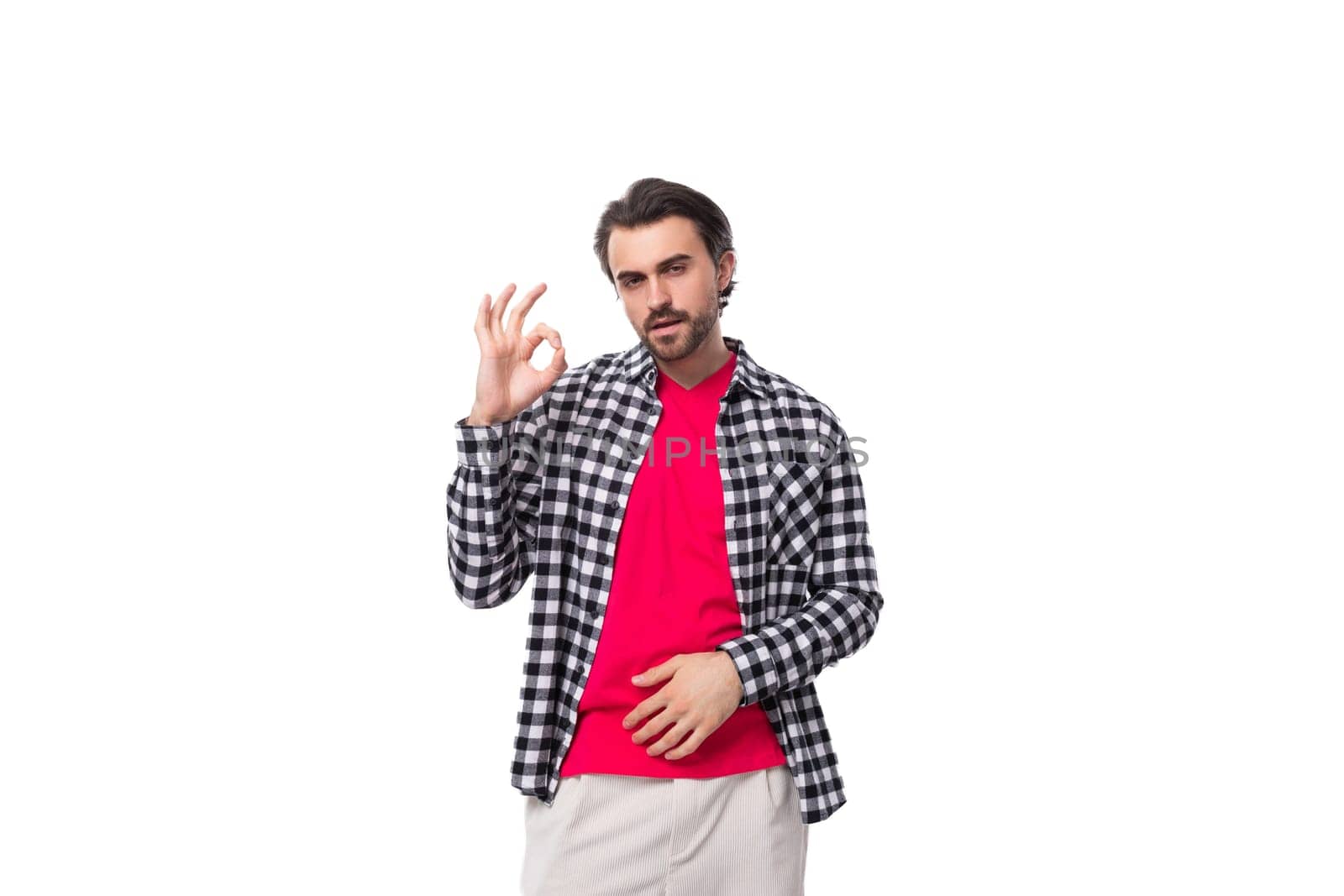 handsome pleasant young european man with black hair and beard in a shirt on a white background with copy space.