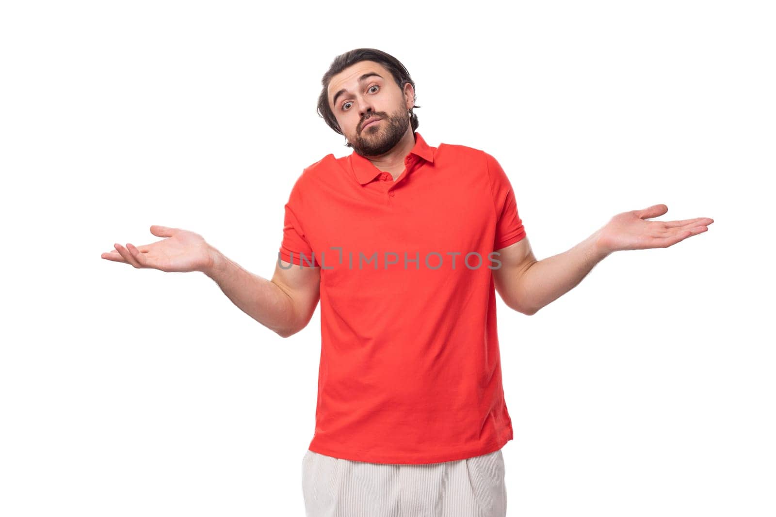 young handsome brunette man in red t-shirt gesturing on white background with copy space.