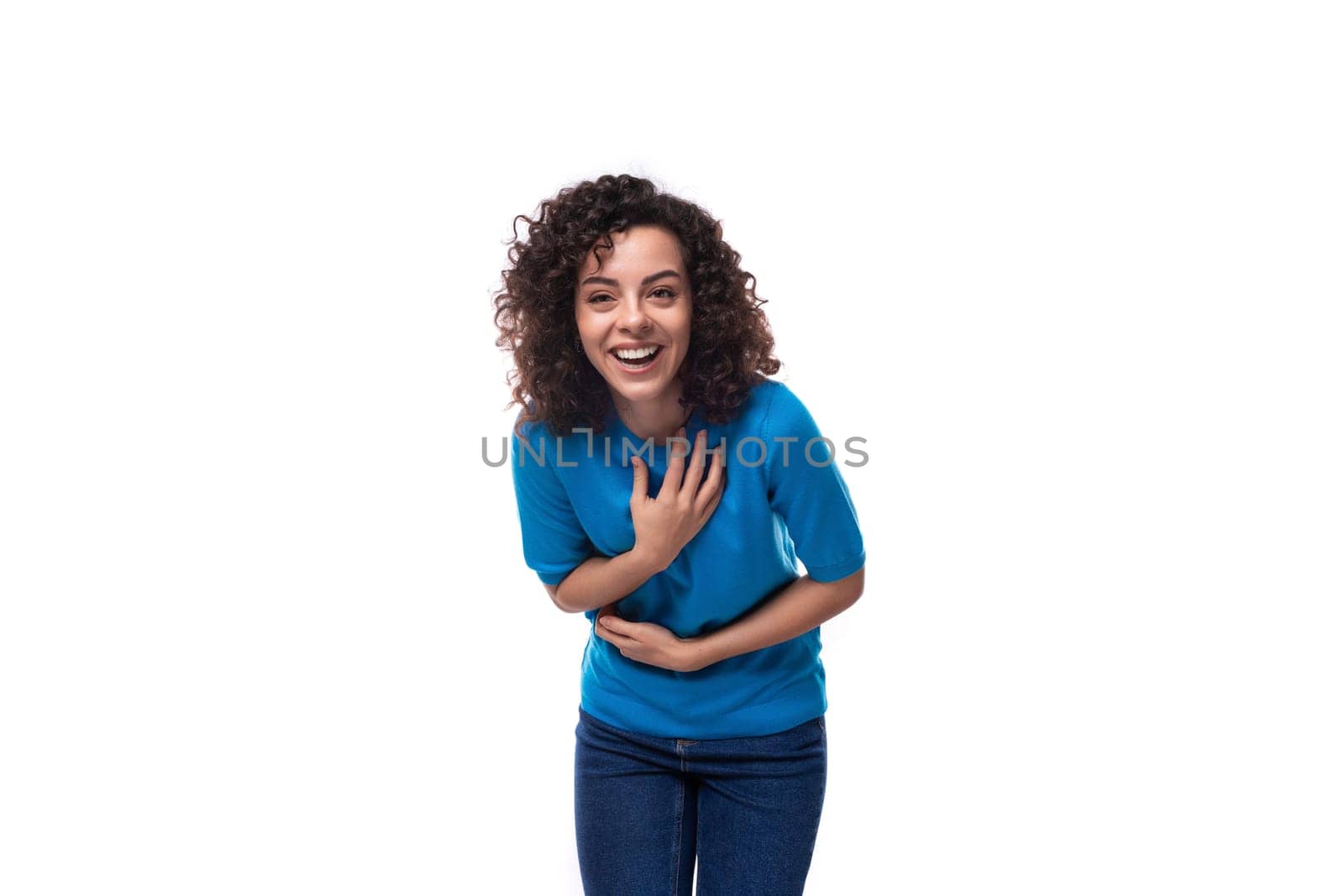 young woman in a blue sweater laughing with open teeth.