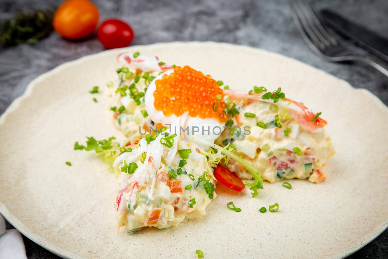 salad with mozzarella, caviar and green onions on a white plate