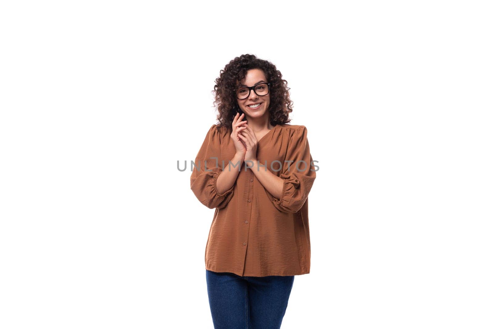 young positive cheerful slender woman with curls dressed in a brown blouse.