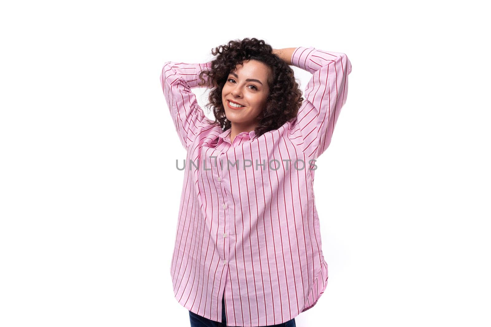 young successful curly caucasian woman dressed in a striped pink blouse.