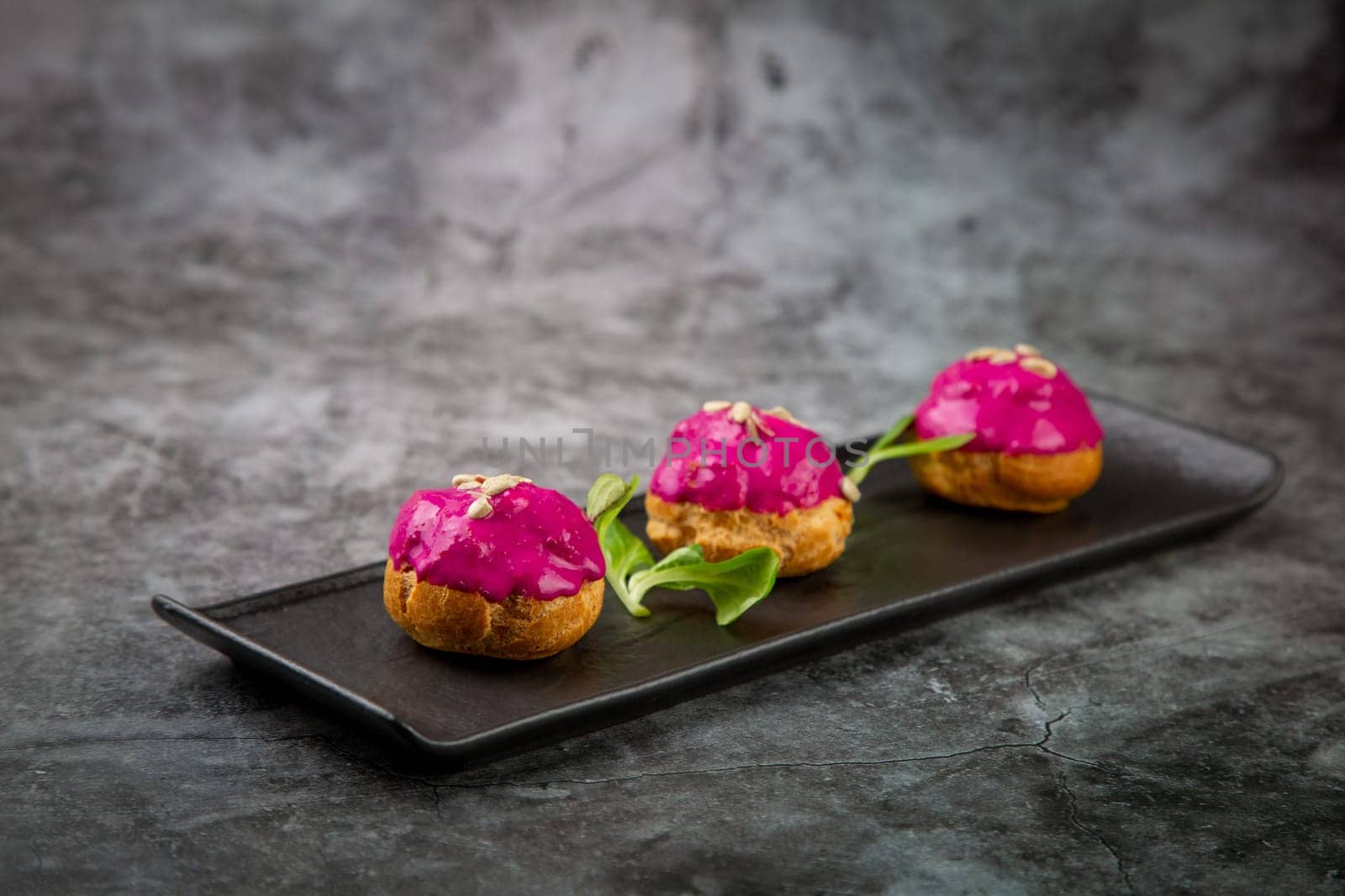 dessert of baked buns with raspberry topping and seed decorations