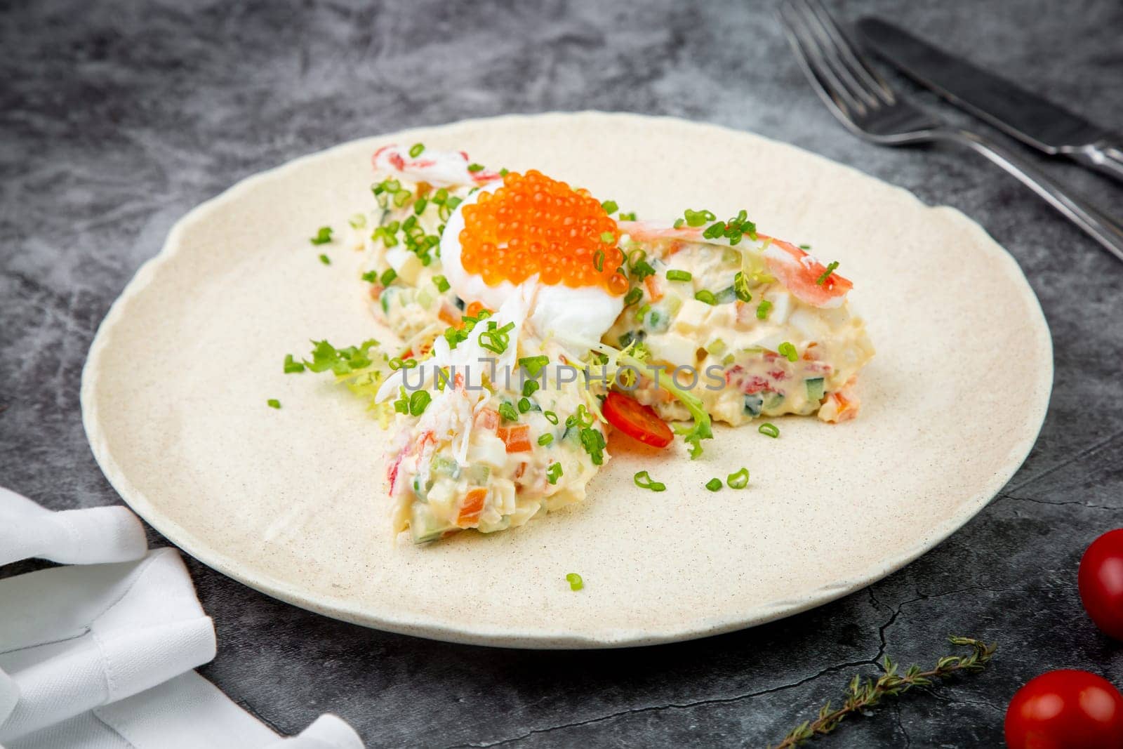 salad with mozzarella, caviar and green onions on a white plate, side view by tewolf