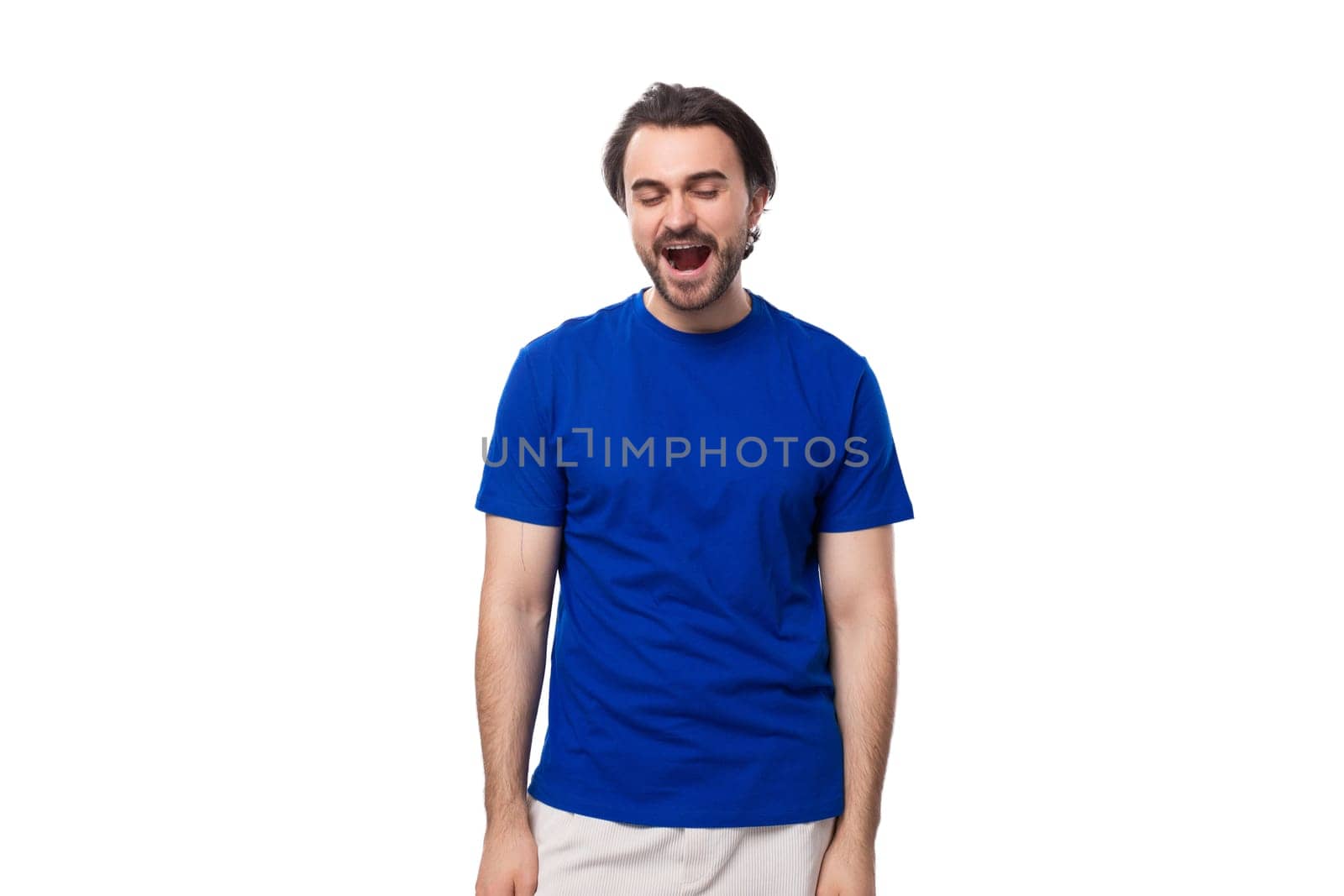 young european brunette man with beard yawns on white background.