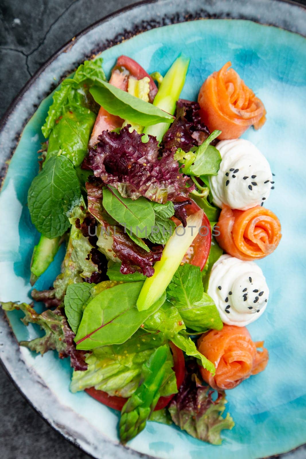 salad of leaves of different types of lettuce and fish rolls, top view by tewolf