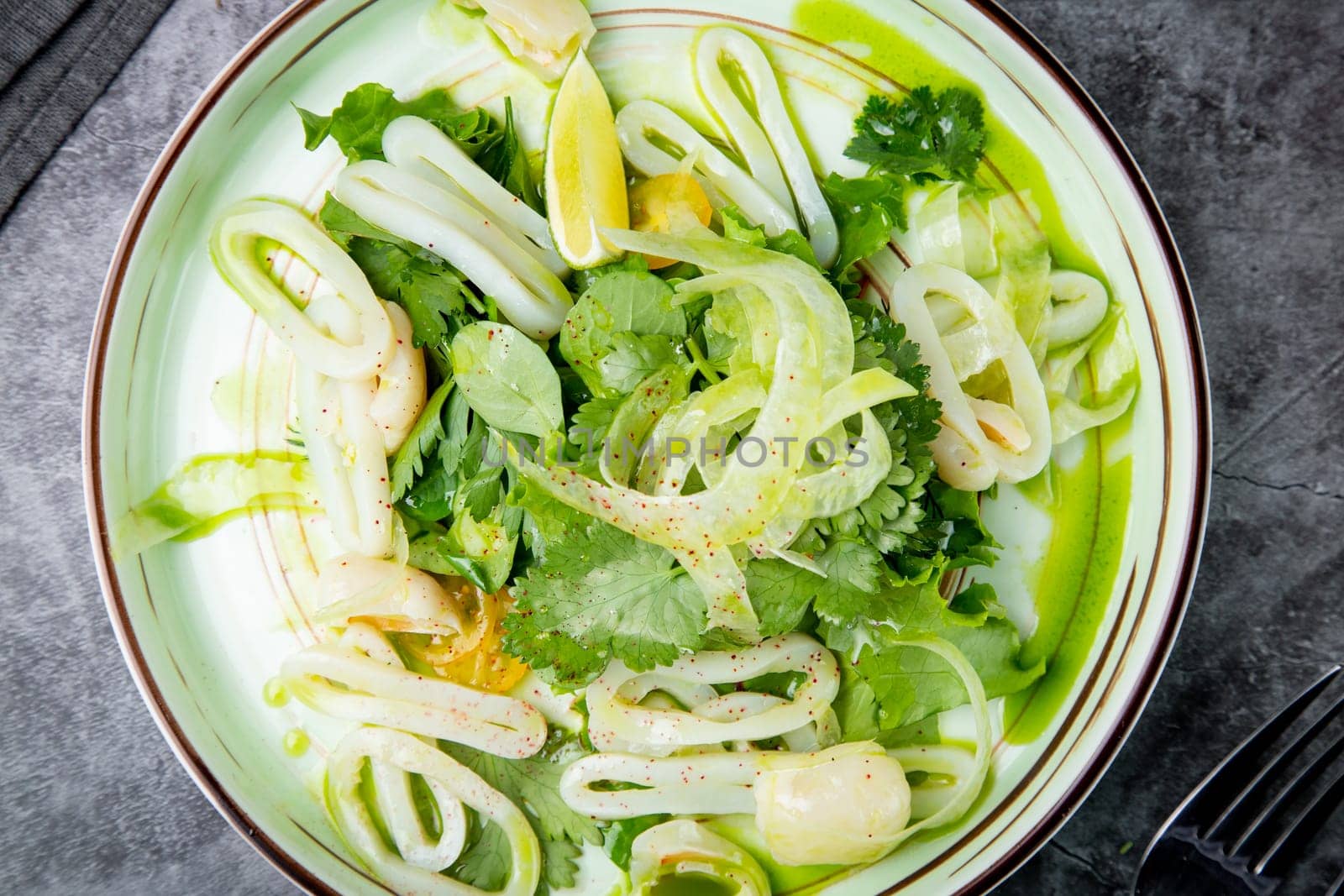 salad with arugula, parsley, lime and squid rings, side view by tewolf