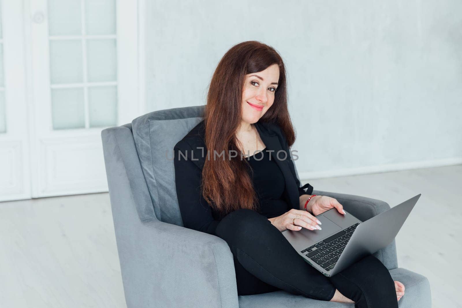 woman working online on laptop from home by Simakov