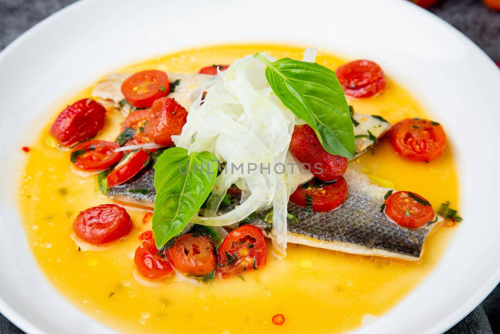 unpeeled fish with gravy, herbs, cherry tomatoes and onions, top view by tewolf