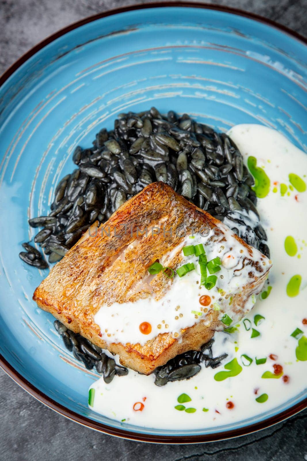 black beans with big fish steak, green onions and cream sauce, top view by tewolf