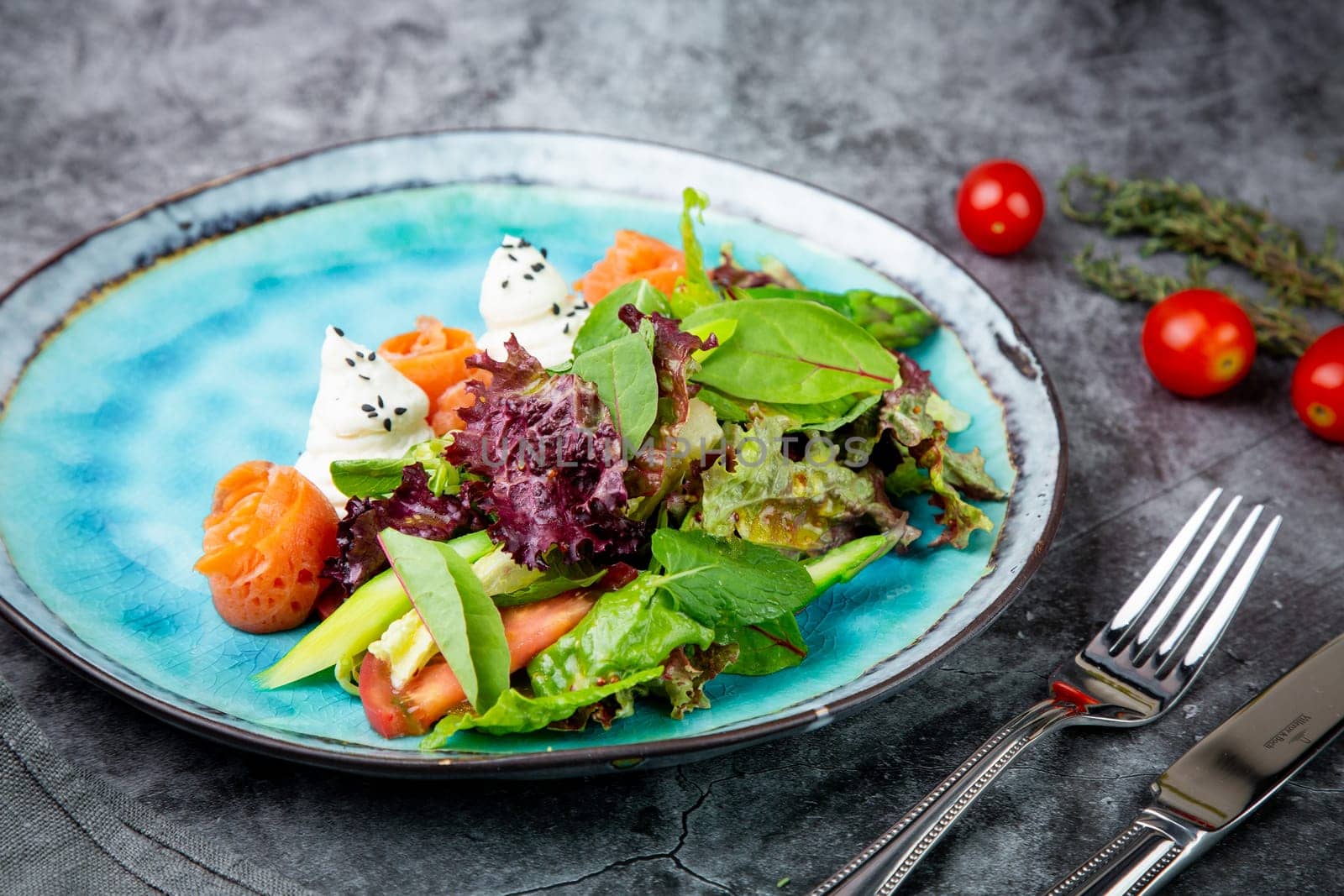 salad of leaves of different types of lettuce and fish rolls, top view by tewolf