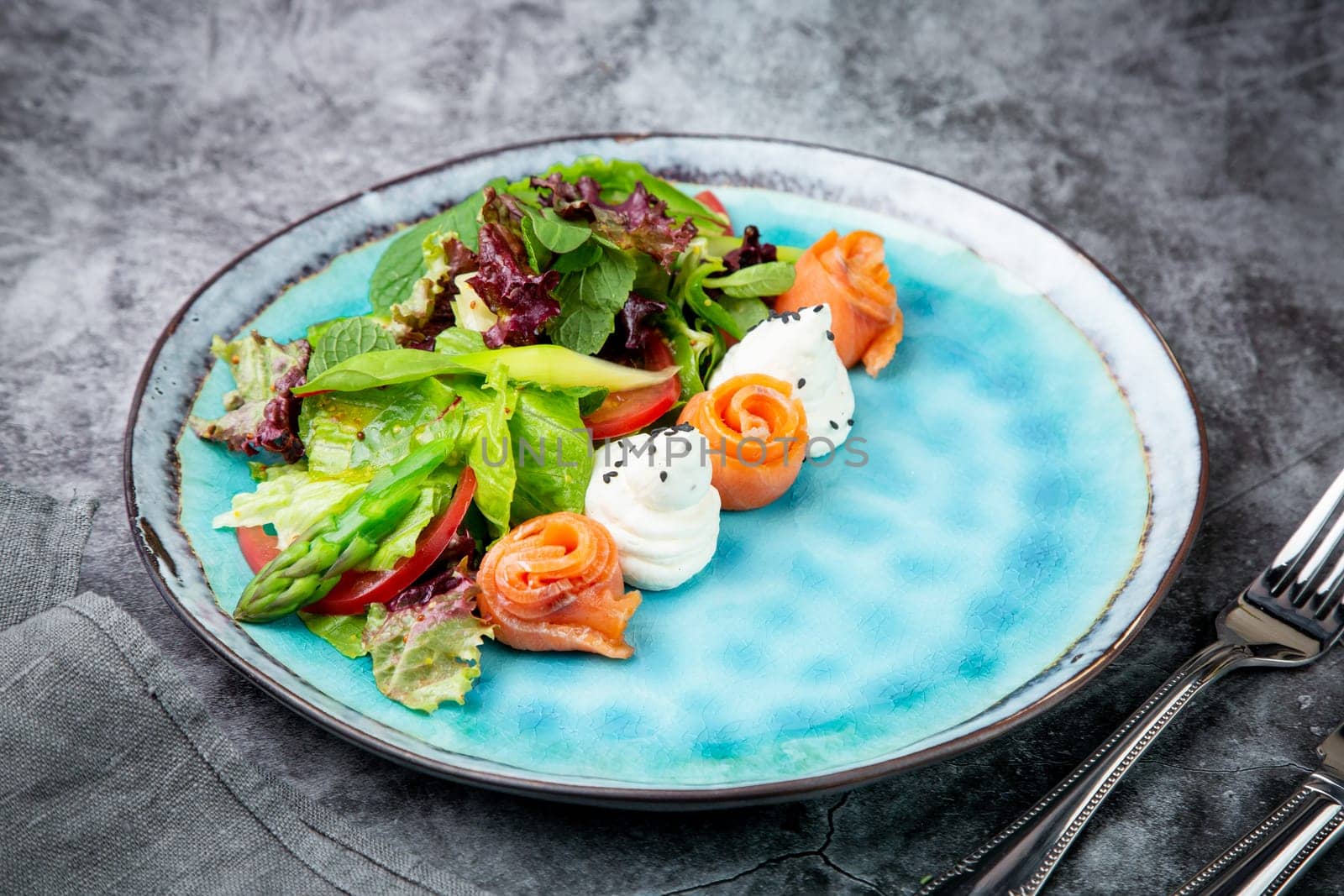 salad of leaves of different types of lettuce and fish rolls, top view by tewolf