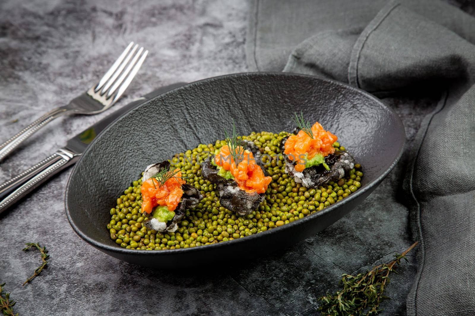 black caviar, red fish and wassabi on a plate with peas