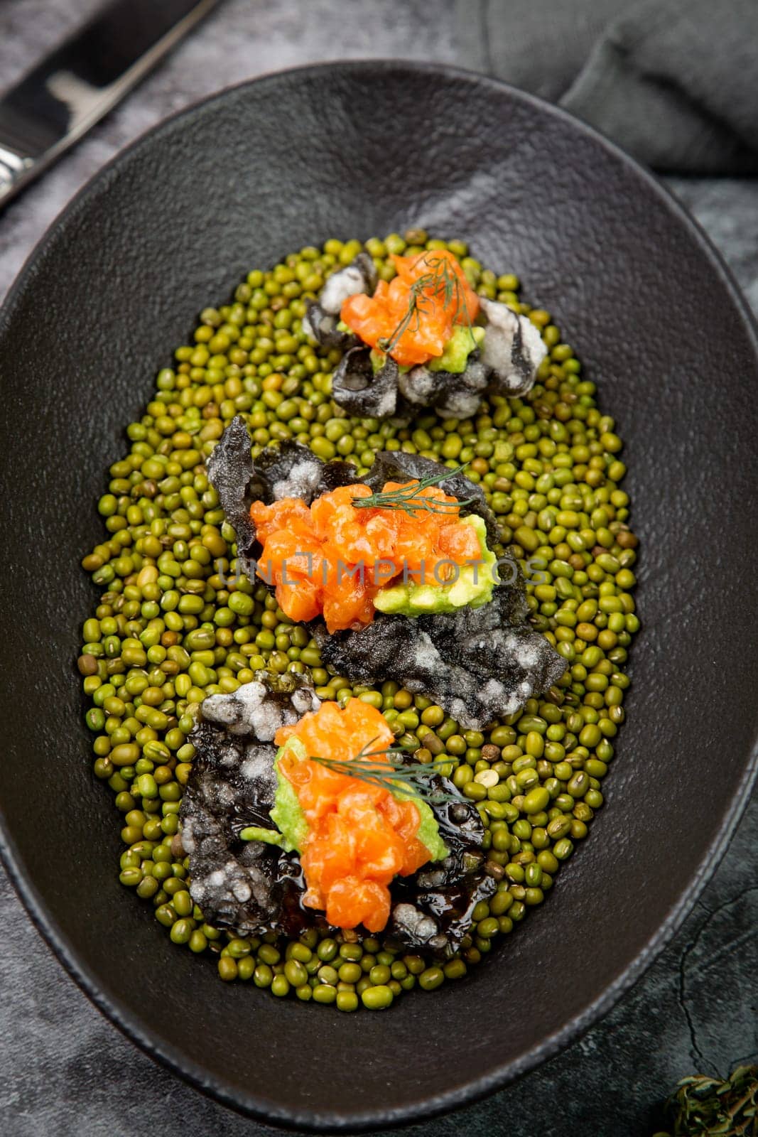black caviar, red fish and wassabi on a plate with peas, top view by tewolf