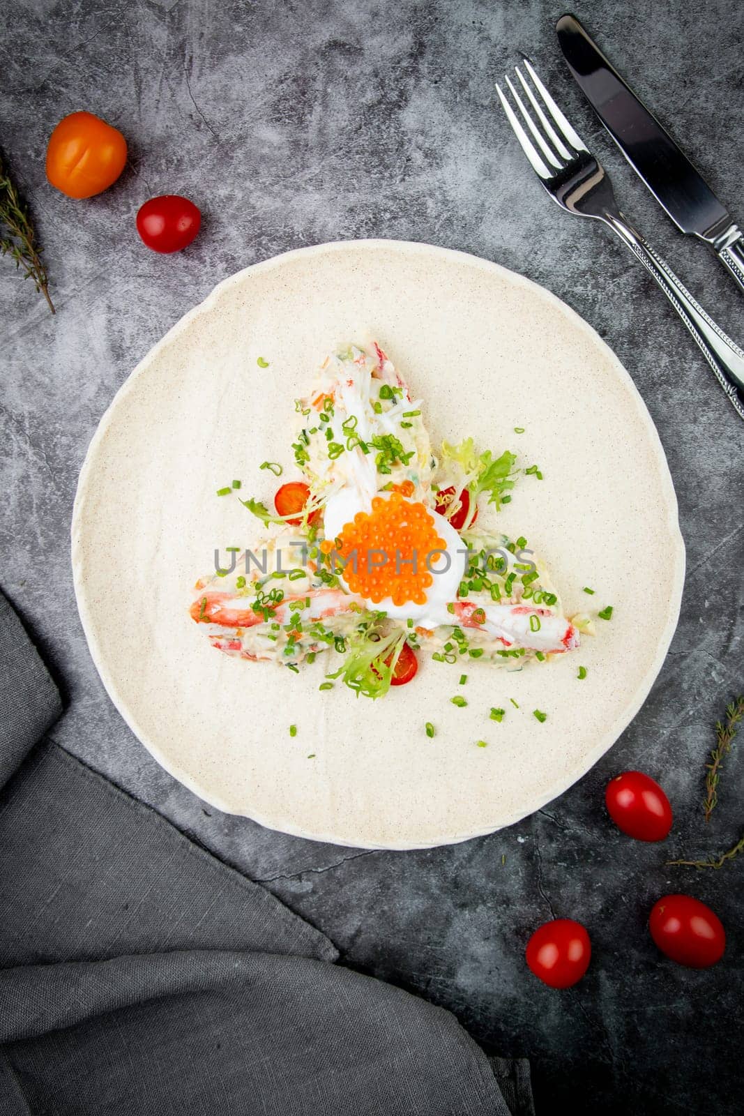 salad with mozzarella, caviar and green onions on a white plate, side view by tewolf