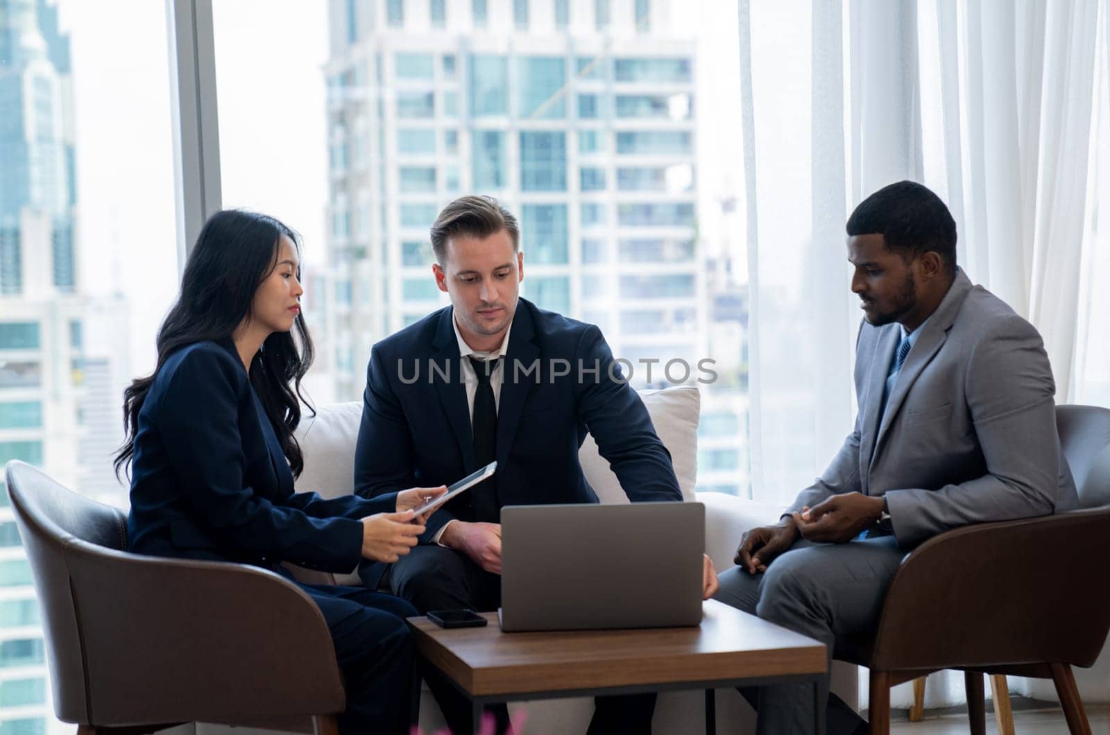 Young smart businesswoman showing data analysis to diverse investor by using tablet. Multicultural business group discussing and investing in start up project. Modern office. Meeting. Ornamented.