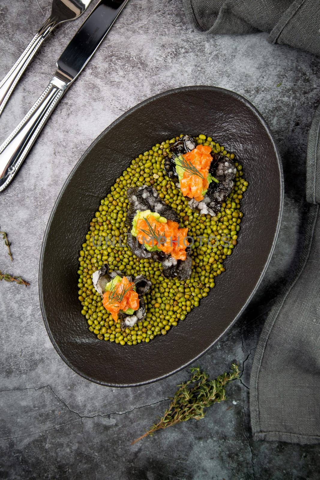 black caviar, red fish and wassabi on a plate with peas