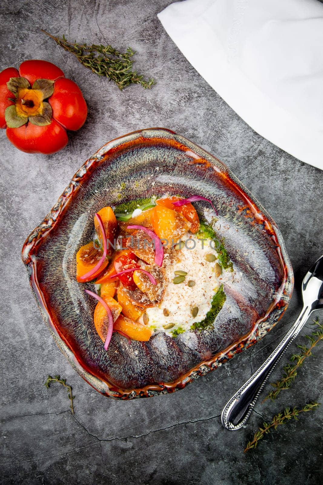 dish of baked persimmons, colored peppers, rice and seeds