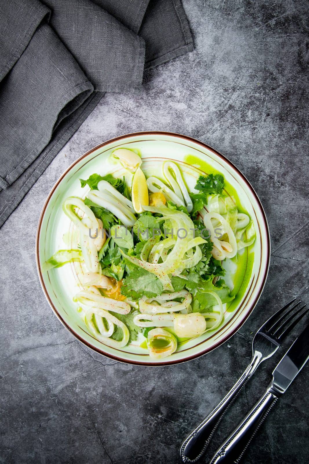 salad with arugula, parsley, lime and squid rings, side view by tewolf